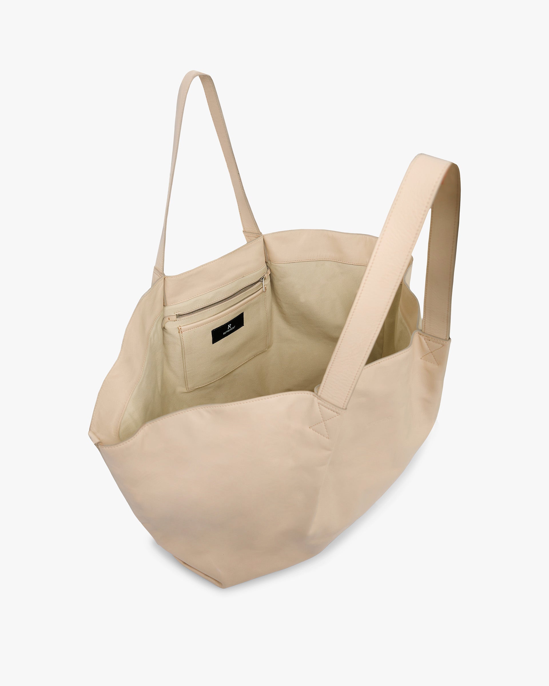 Back product image of a womens taupe leather tote on a plain white background | Leather Pleat Large Tote in Taupe | Large tote with internal pockets and shoulder strap | Womens SS25 Accessories | Represent Clo