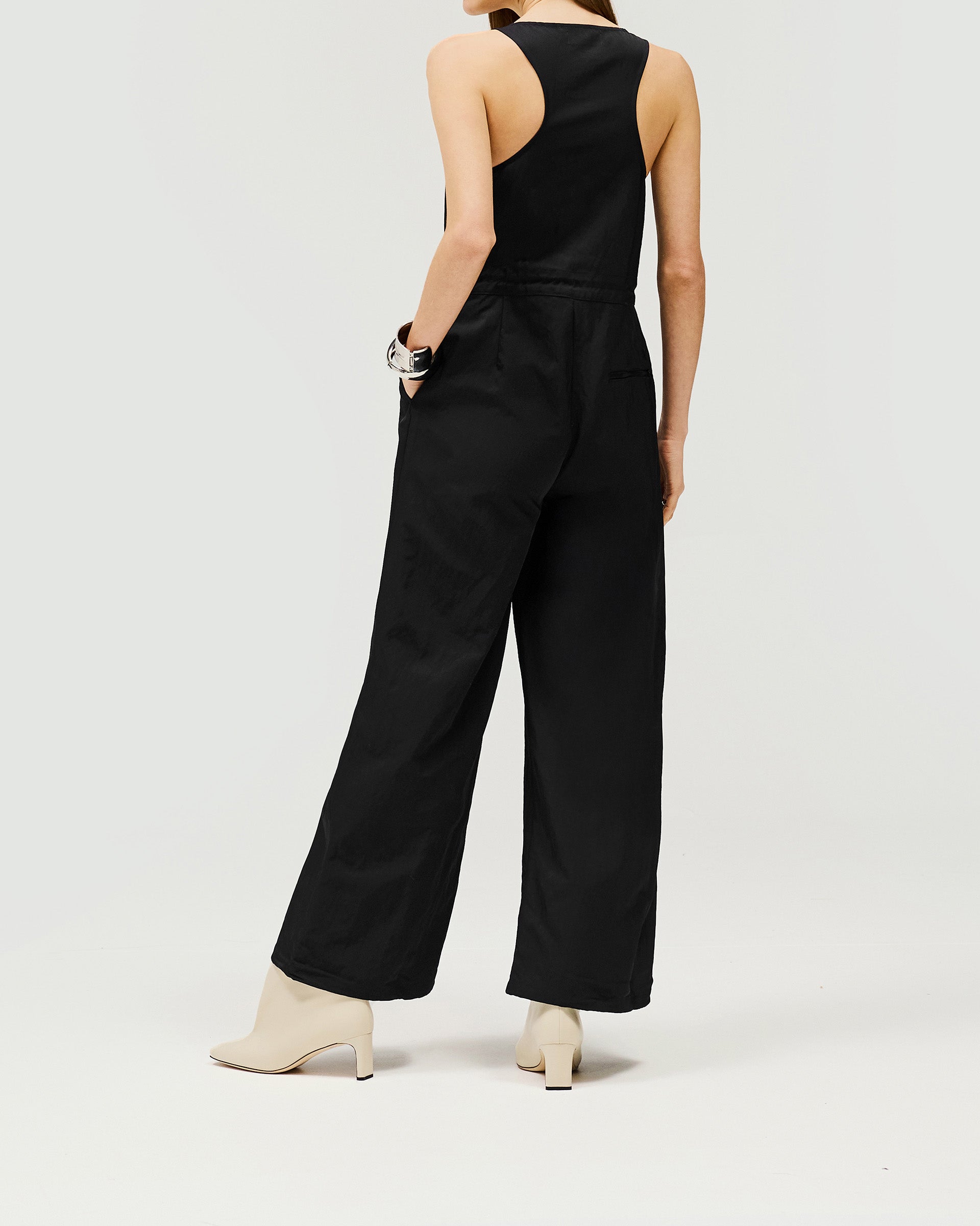 Back product image of a womens black jumpsuit on a plain white background | Subway Jumpsuit in Jet Black | Nylon jumpsuit with adjustable drawstring waist | Womens SS25 Jumpsuits | Represent Clo