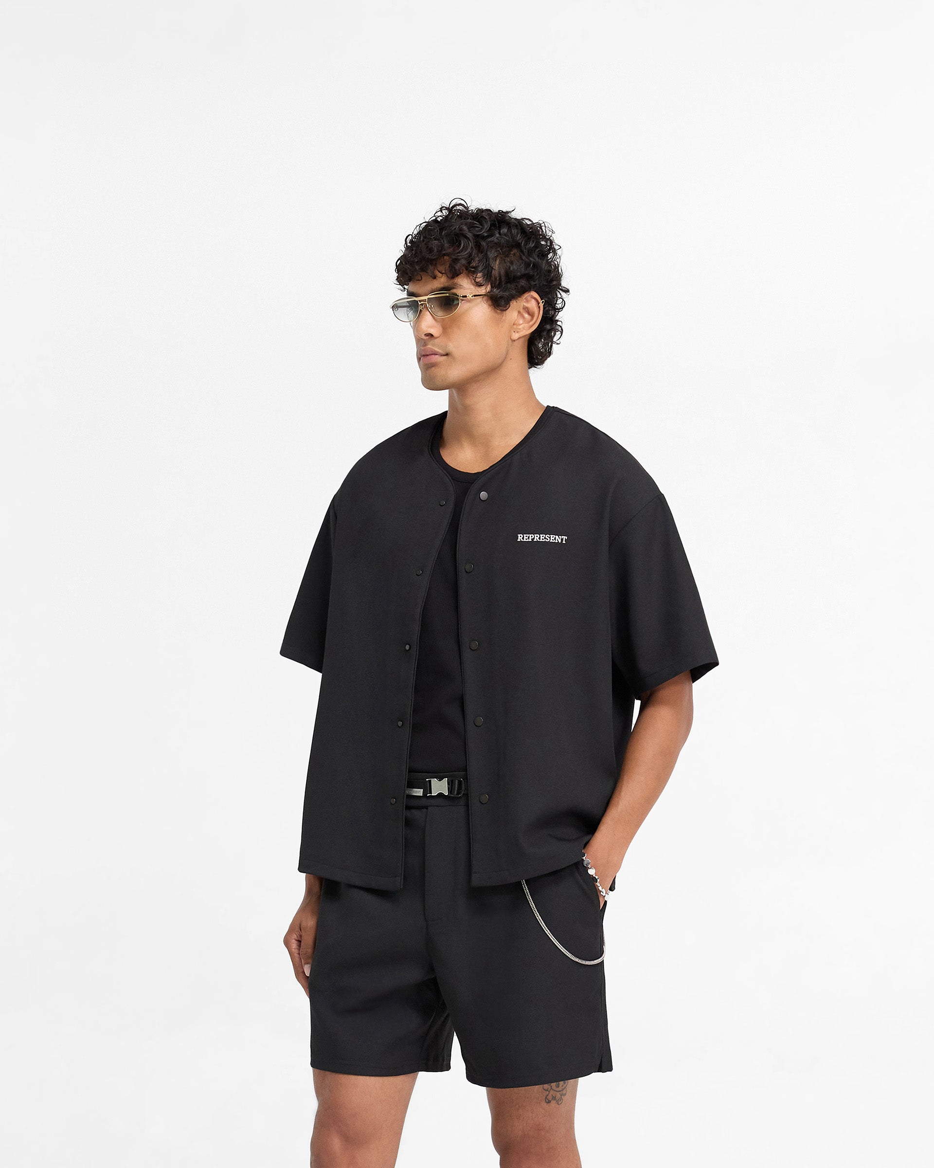 Back product image of a mens black shirt on a plain white background | Baseball Shirt in Black | Collarless shirt with popper buttons and embroidered logo | FW24 Shirts | Represent Clo