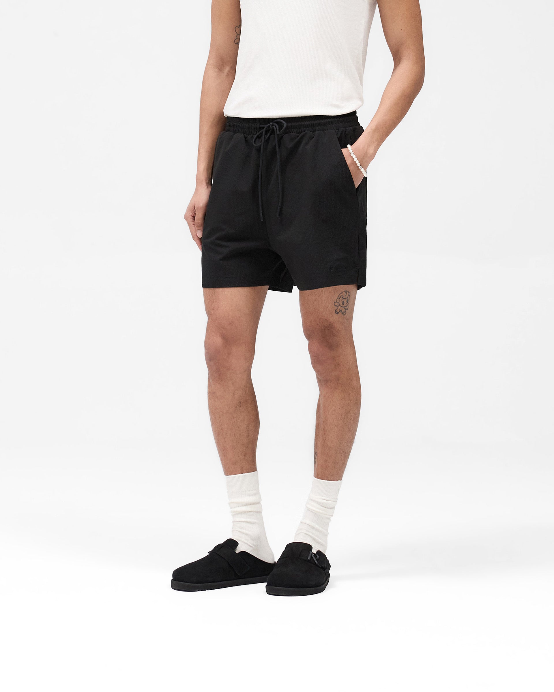 Back product image of mens black swim shorts on a plain white background | Seersucker Smart Swim Short in Black | Textured seersucker swim shorts with mesh liner and key pocket | SS25 Shorts | Represent Clo