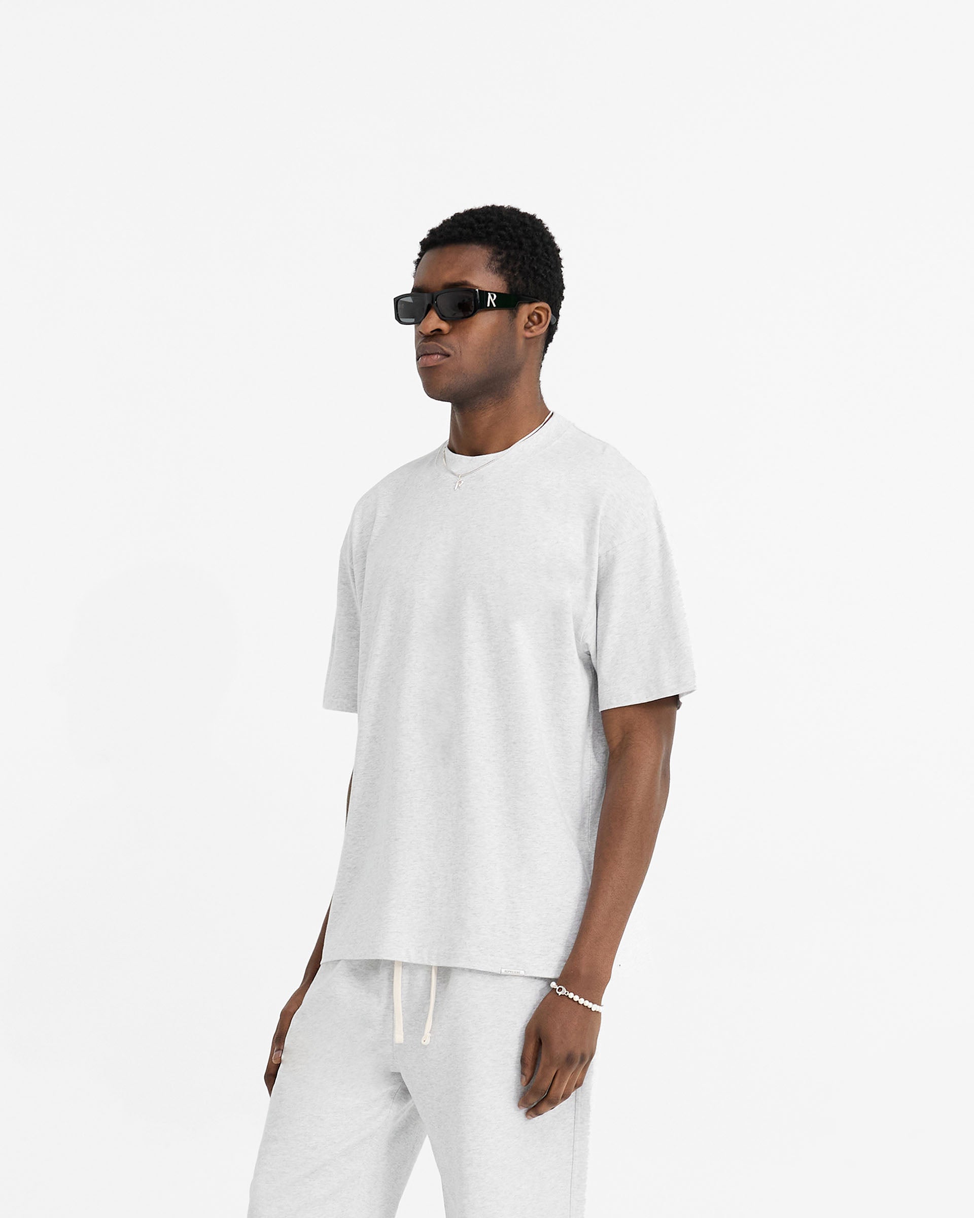 Back product image of a mens grey t-shirt on a plain white background | Initial Oversized T-Shirt in Ice Grey Marl | Oversized t-shirt with embroidered back neck Initial | Initial T-Shirts | Represent Clo