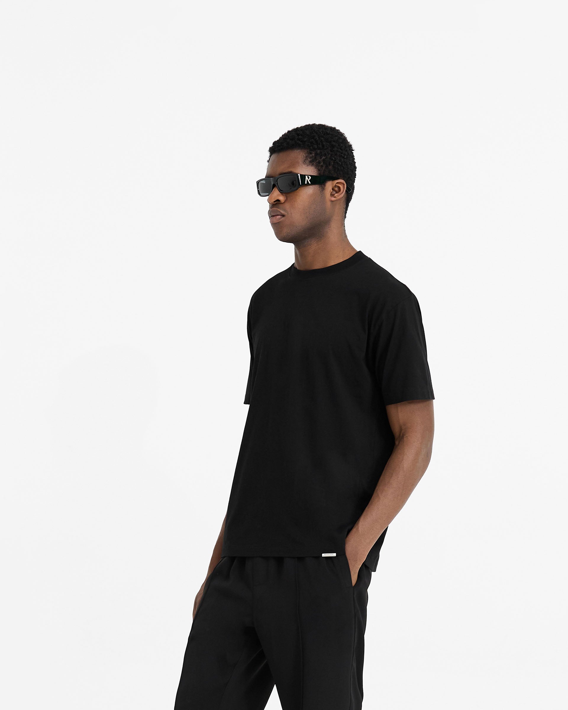 Back product image of a mens black t-shirt on a plain white background | Initial T-Shirt in Black | Regular fit t-shirt with embroidered initial and metal bar logo | Initial T-Shirts | Represent Clo
