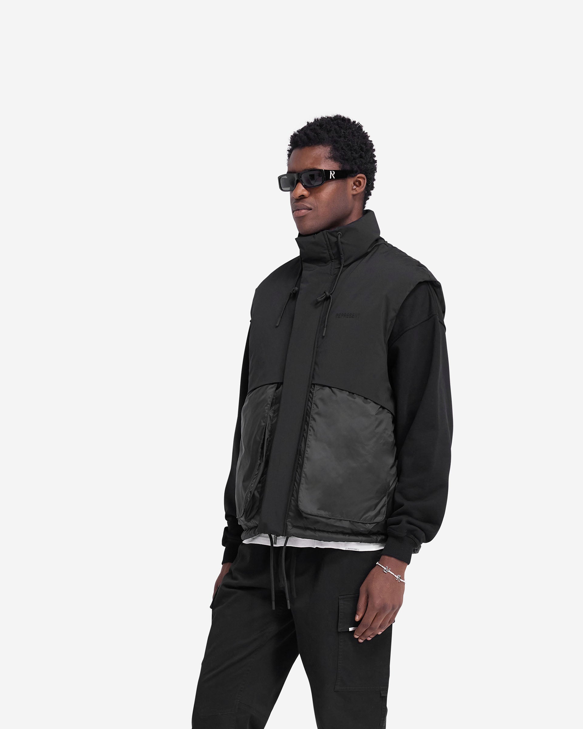 Back product image of a mens black puffer gilet on a plain white background | Layered Puffer Gilet in Jet Black | Duck down filled gilet with adjustable hem and storm flaps | FW24 Outerwear | Represent Clo