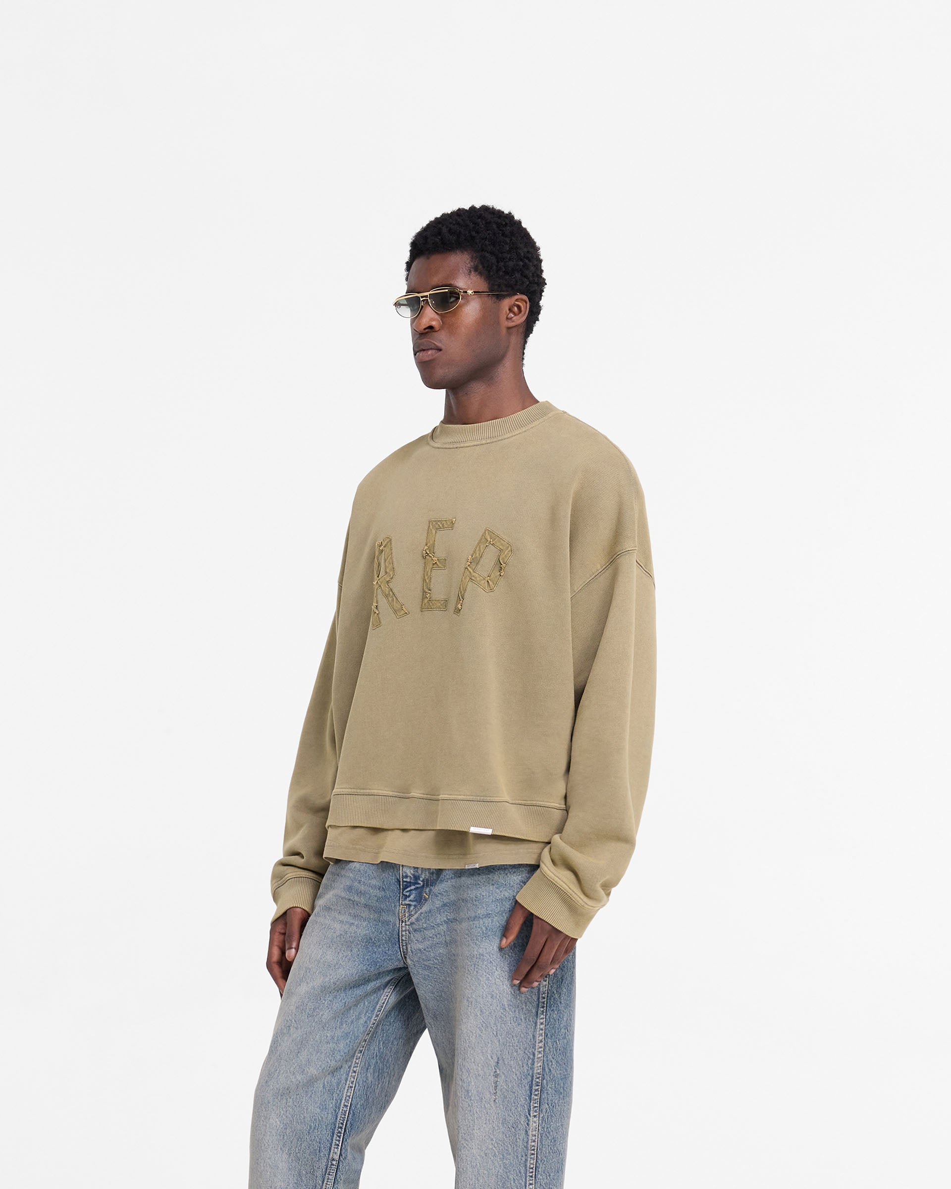 Back product image of a mens fawn sweater on a plain white background | Rep Applique Sweater in Fawn | Oversized boxy fit sweater with sun fade wash | FW24 Sweaters | Represent Clo