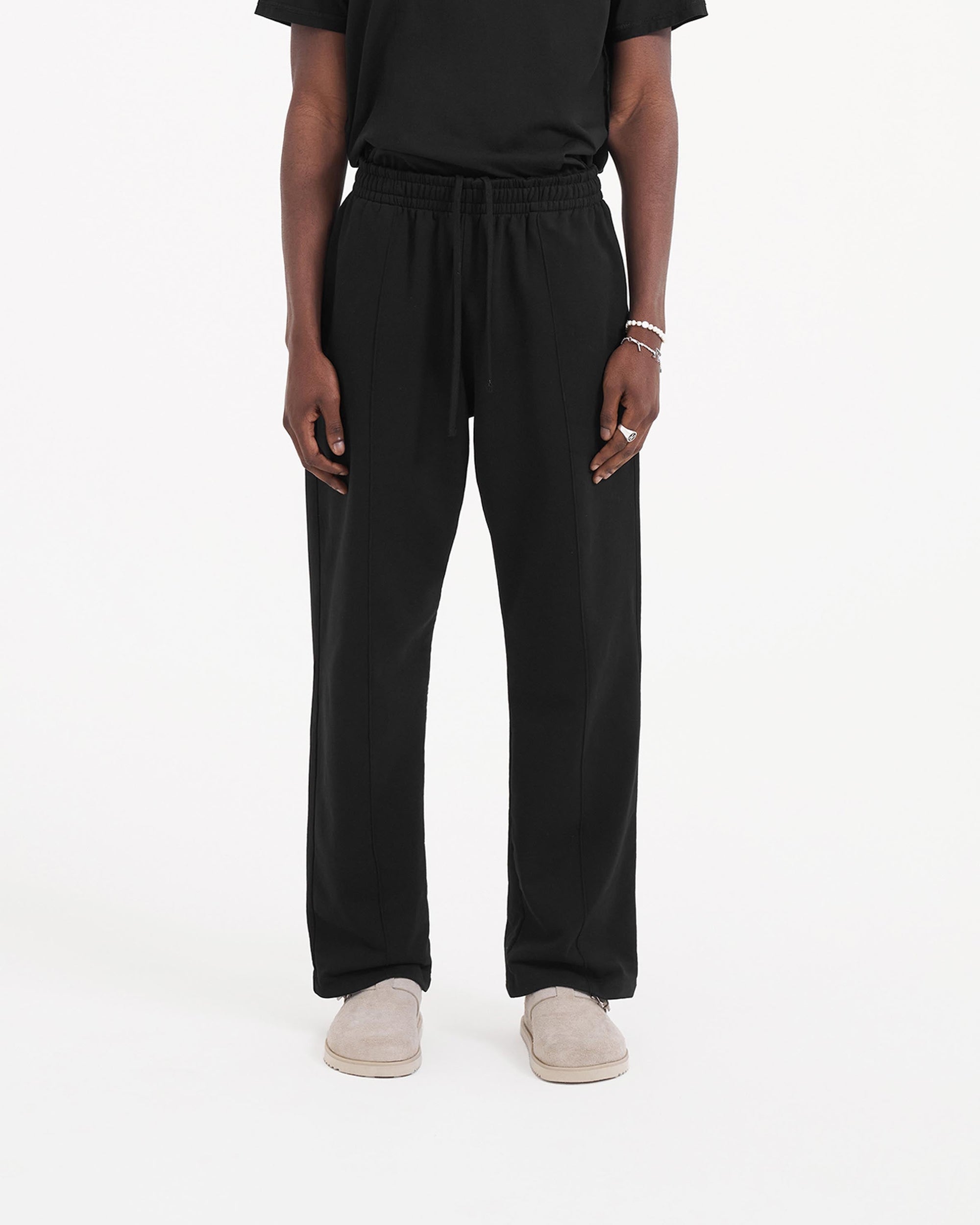 Back product image of mens black sweatpants on a plain white background | Initial Sweatpant in Jet Black | Wide leg sweatpants with pleat detail | Initial Pants | Represent Clo