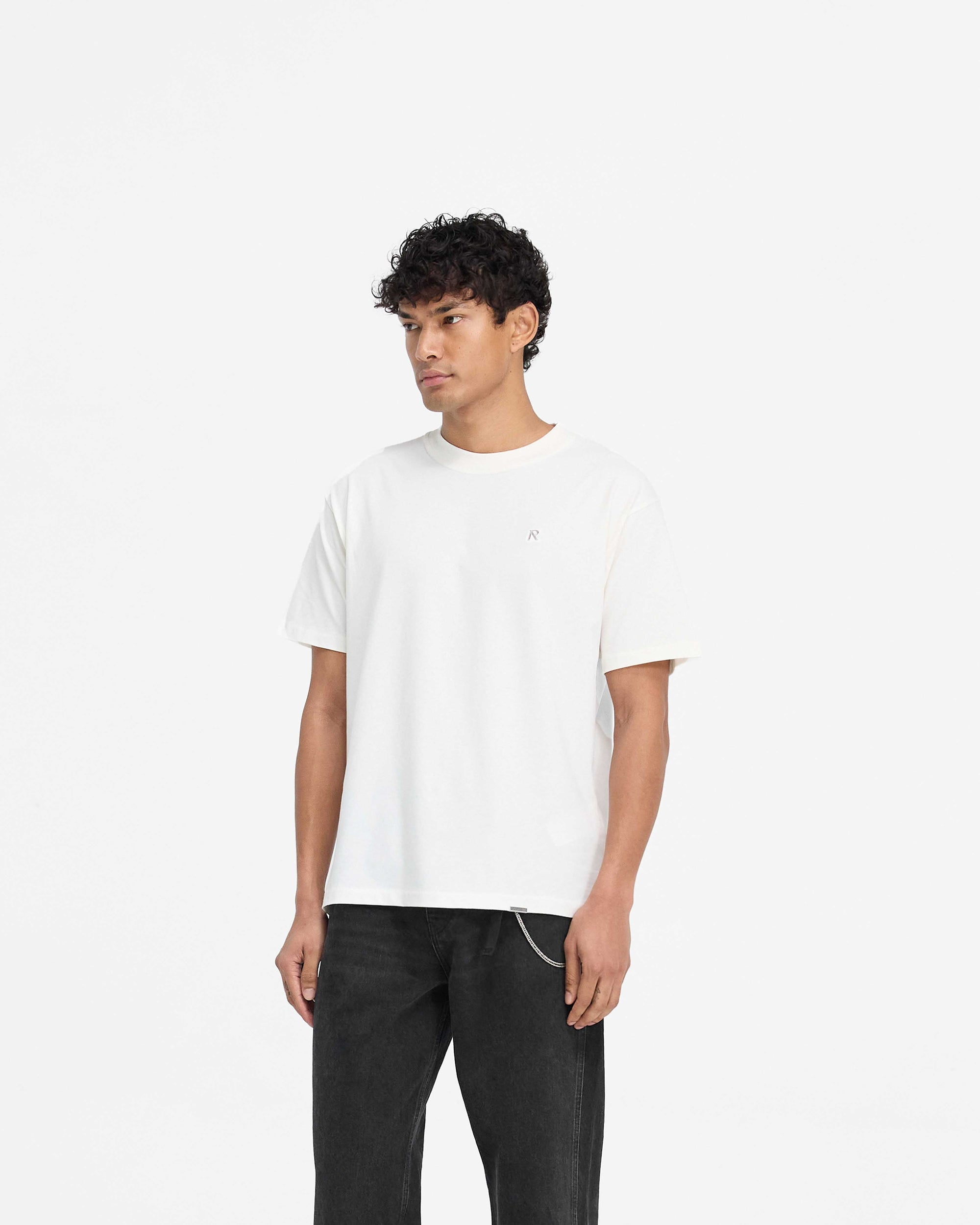 Back product image of a mens white t-shirt on a plain white background | Metal Initial R T-Shirt in Flat White | Slim fit cotton t-shirt with metal logo | PRE SS25 T-Shirts | Represent Clo