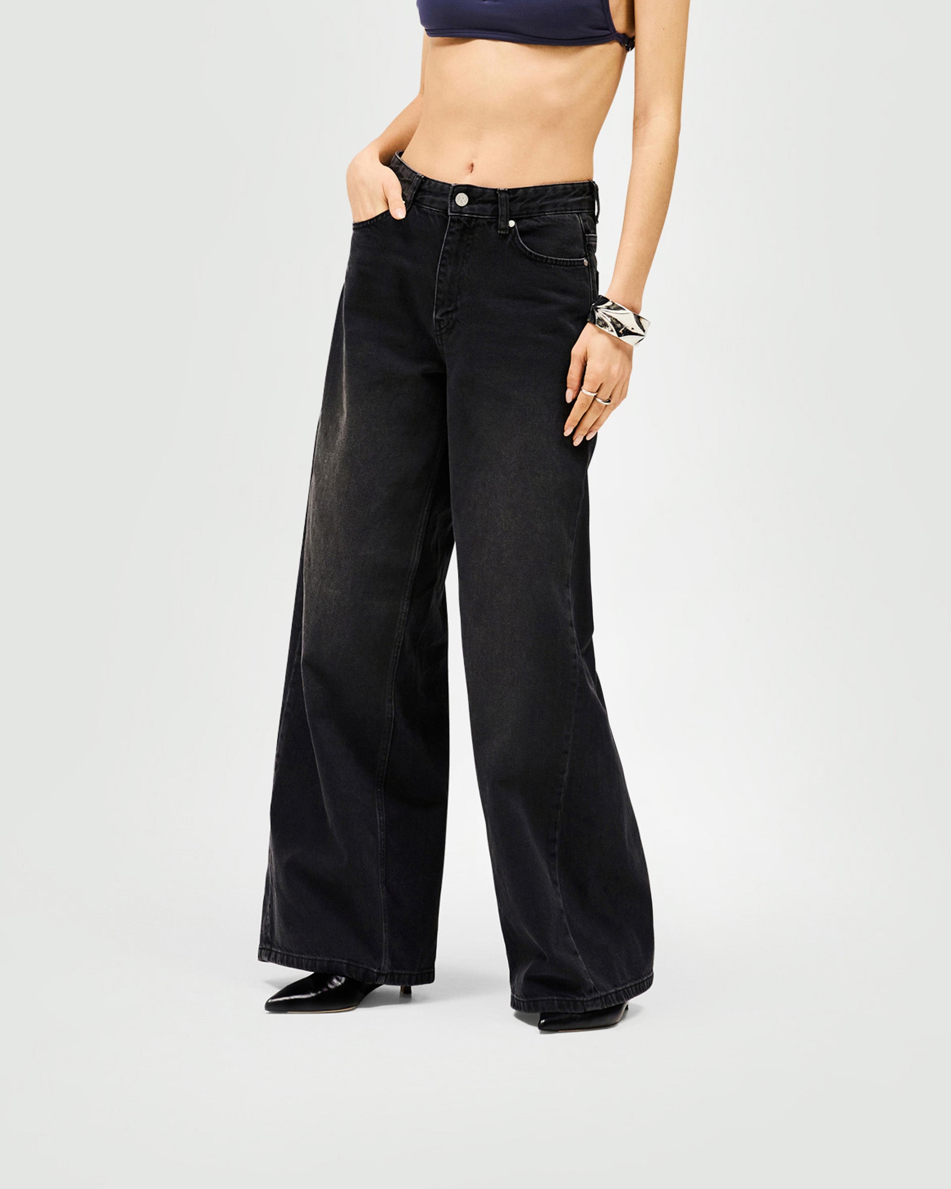 Back product image of womens black jeans on a plain white background | Mid Rise Wide Leg Jean in Washed Black | High-quality denim with leather branded patch | Womens SS25 Jeans | Represent Clo