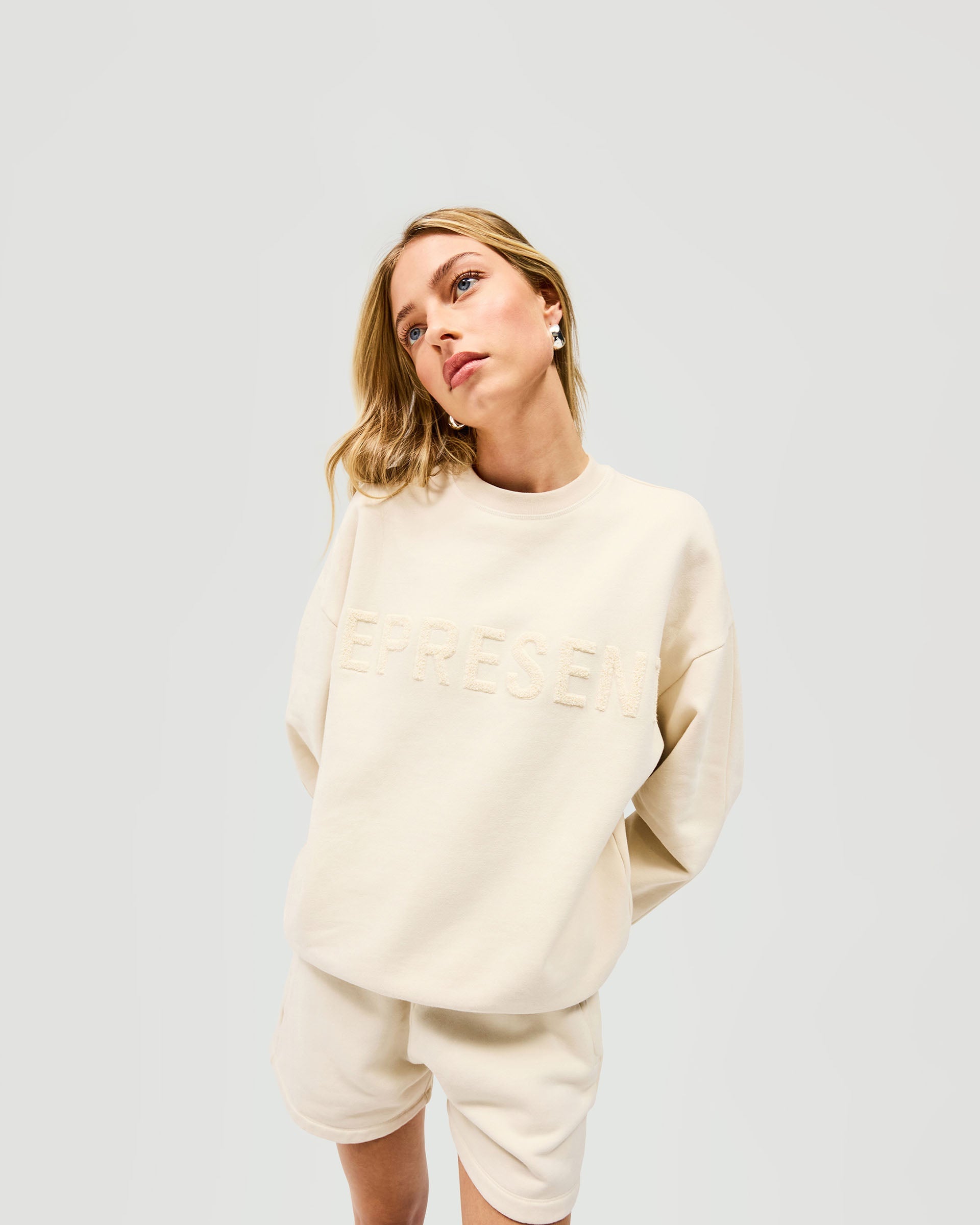 Back product image of a womens white sweater on a plain white background | Owners Club Sweater in Oat Milk | Sweater with ribbed hem and relaxed fit | Womens Owners Club Sweaters | Represent Clo