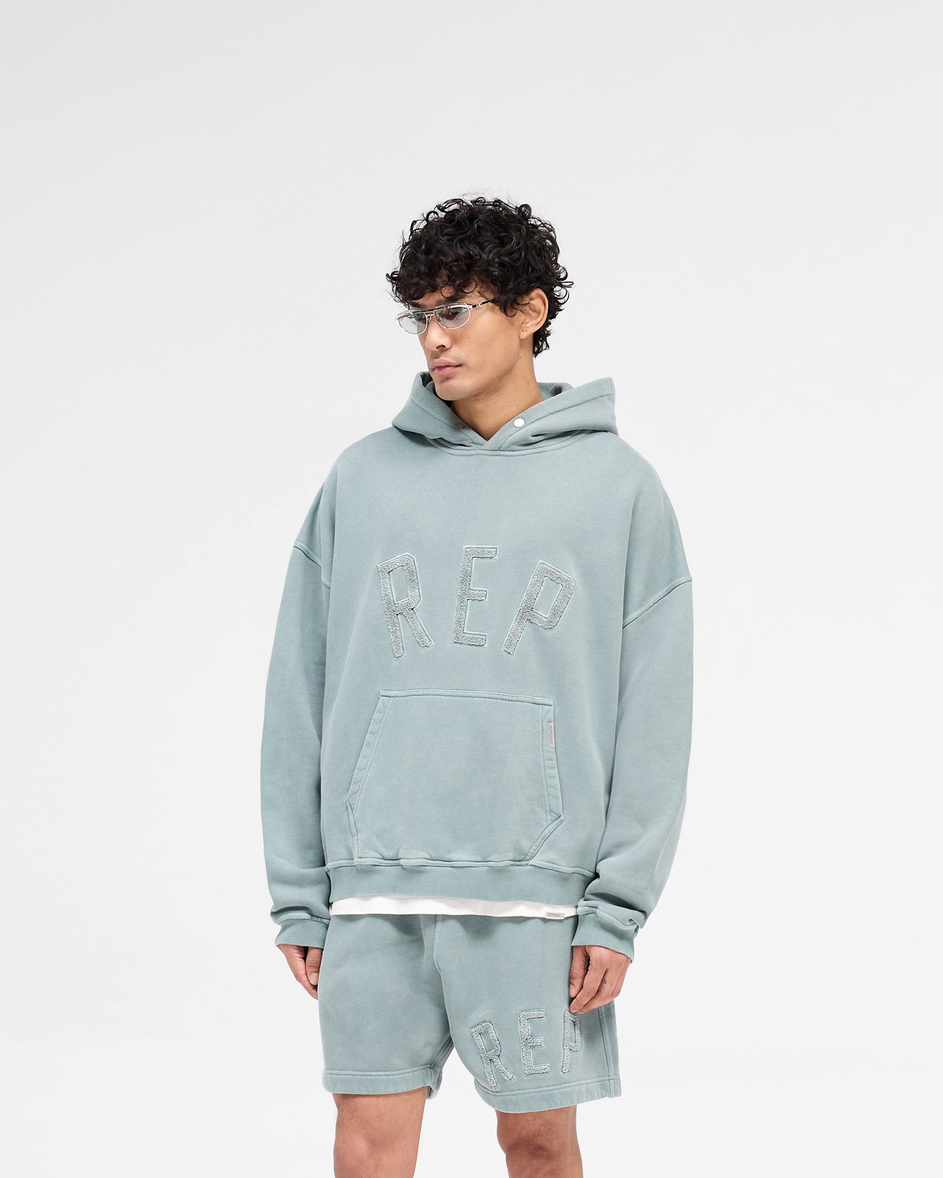 Back product image of a mens green hoodie on a plain white background | Rep Applique Hoodie in Forest Green | Boxy fit hoodie with textured Rep applique | SS25 Hoodies | Represent Clo