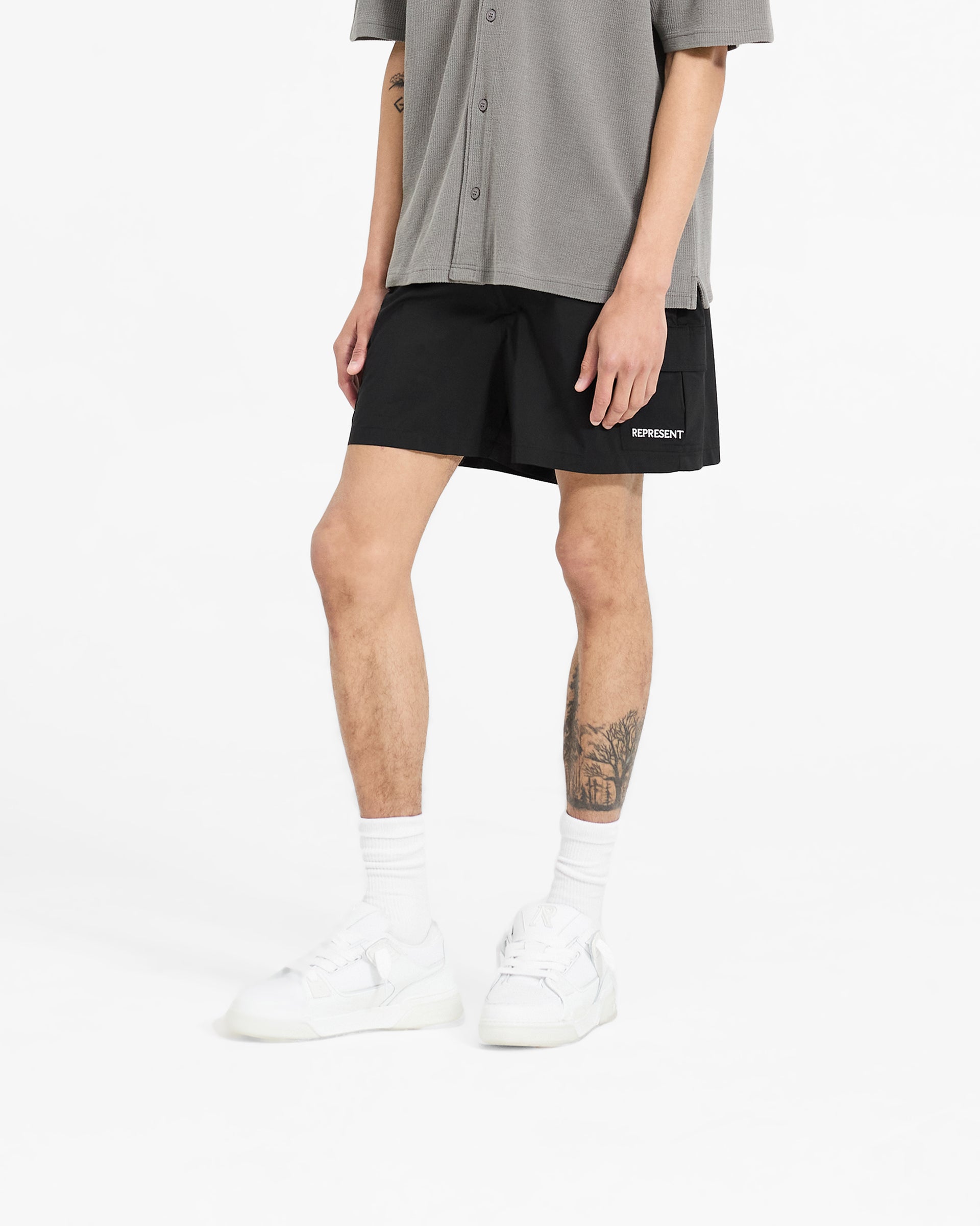 Back product image of mens black shorts on a plain white background | Cargo Swim Shorts in Jet Black | Cargo swim shorts with mesh lining and buckle adjusters | SC24 Shorts | Represent Clo