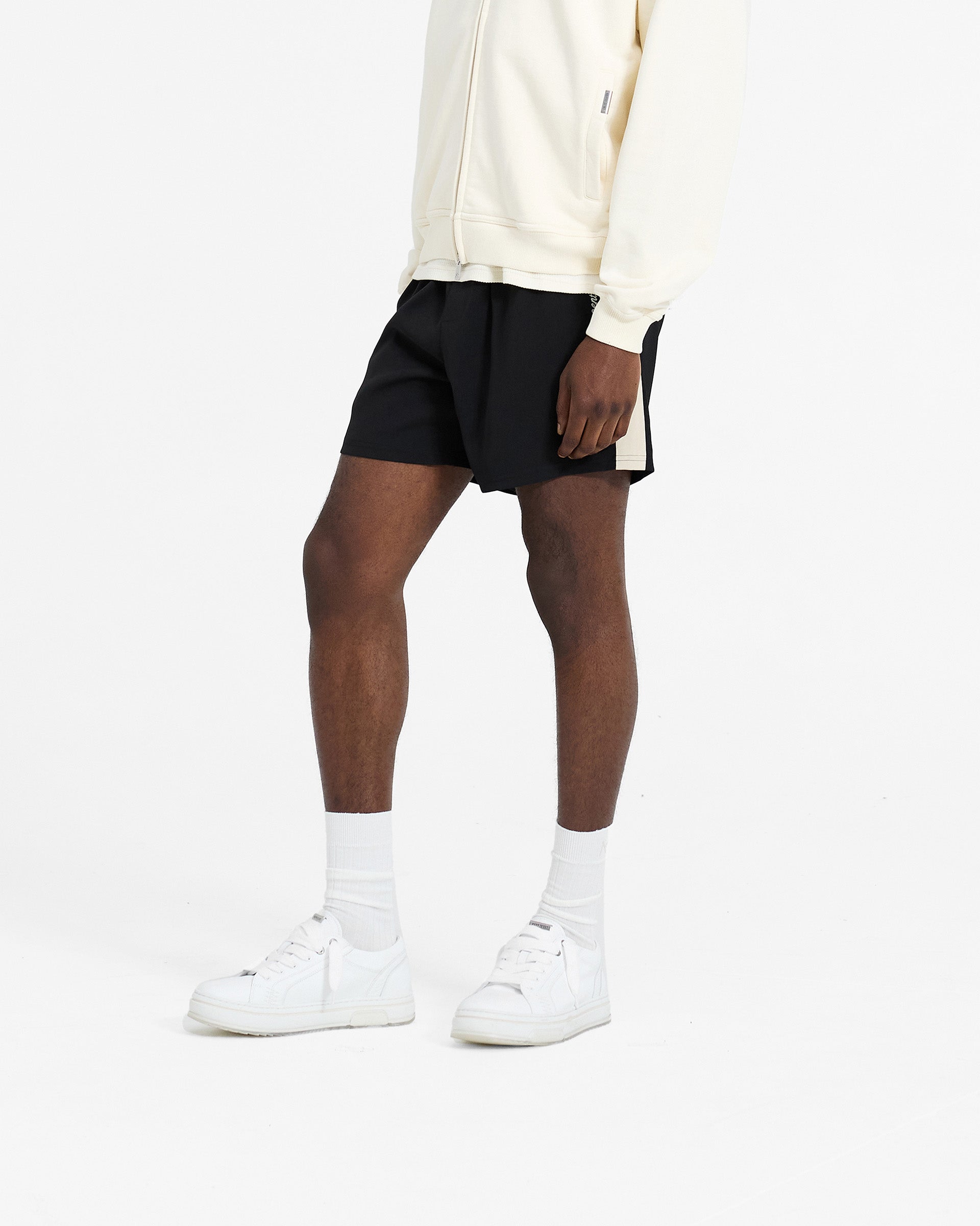 Back product image of mens black shorts on a plain white background | Track Short in Jet Black | Shorts with elasticated waistband and contrast panelling | SC24 Shorts | Represent Clo