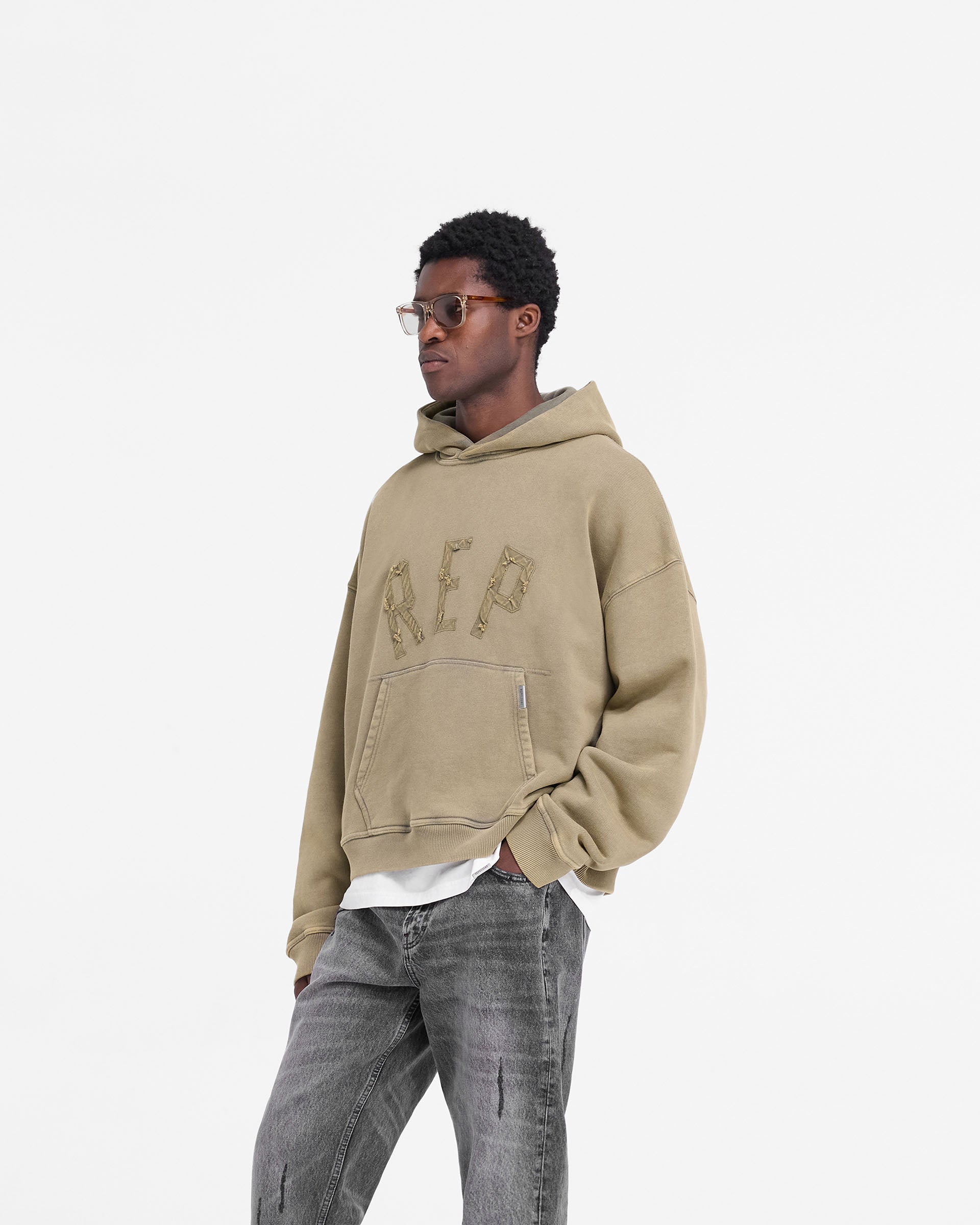 Back product image of a mens fawn hoodie on a plain white background | Rep Applique Hoodie in Fawn | Oversized boxy fit hoodie with ribbed hem and cuffs | FW24 Hoodies | Represent Clo