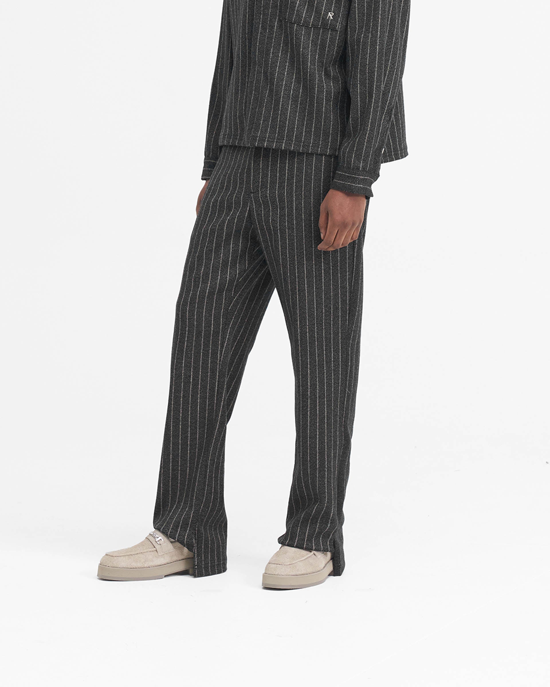 Back product image of mens black pinstripe pants on a plain white background | Stepped Hem Pant in Black Pinstripe | Wide leg pants with split hem and twill finish | SS24 Pants | Represent Clo