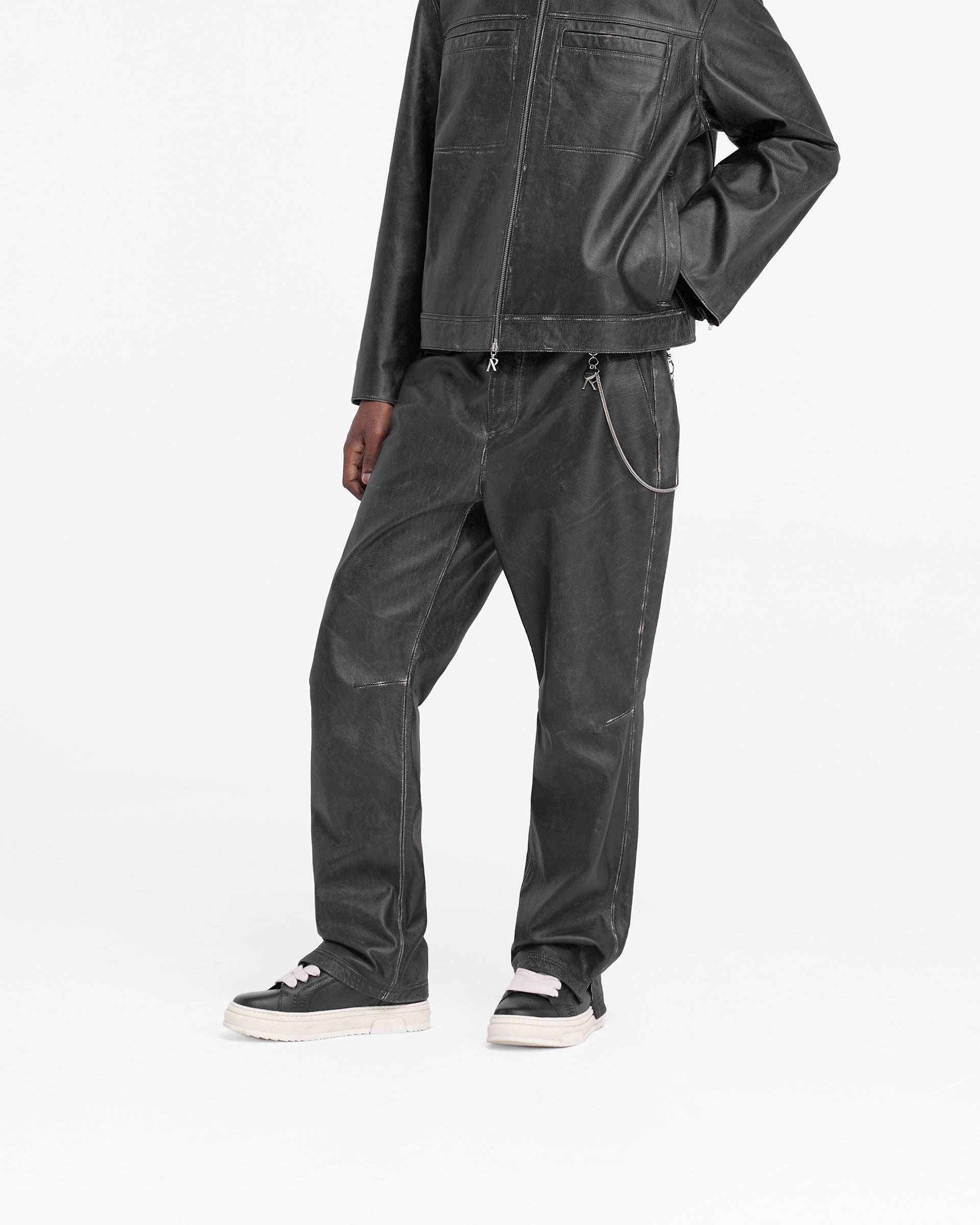 Back product image of mens black leather pants on a plain white background | Distressed Leather Pant in Black | Hand distressed leather wide fit pants with split hem | FW24 Pants | Represent Clo