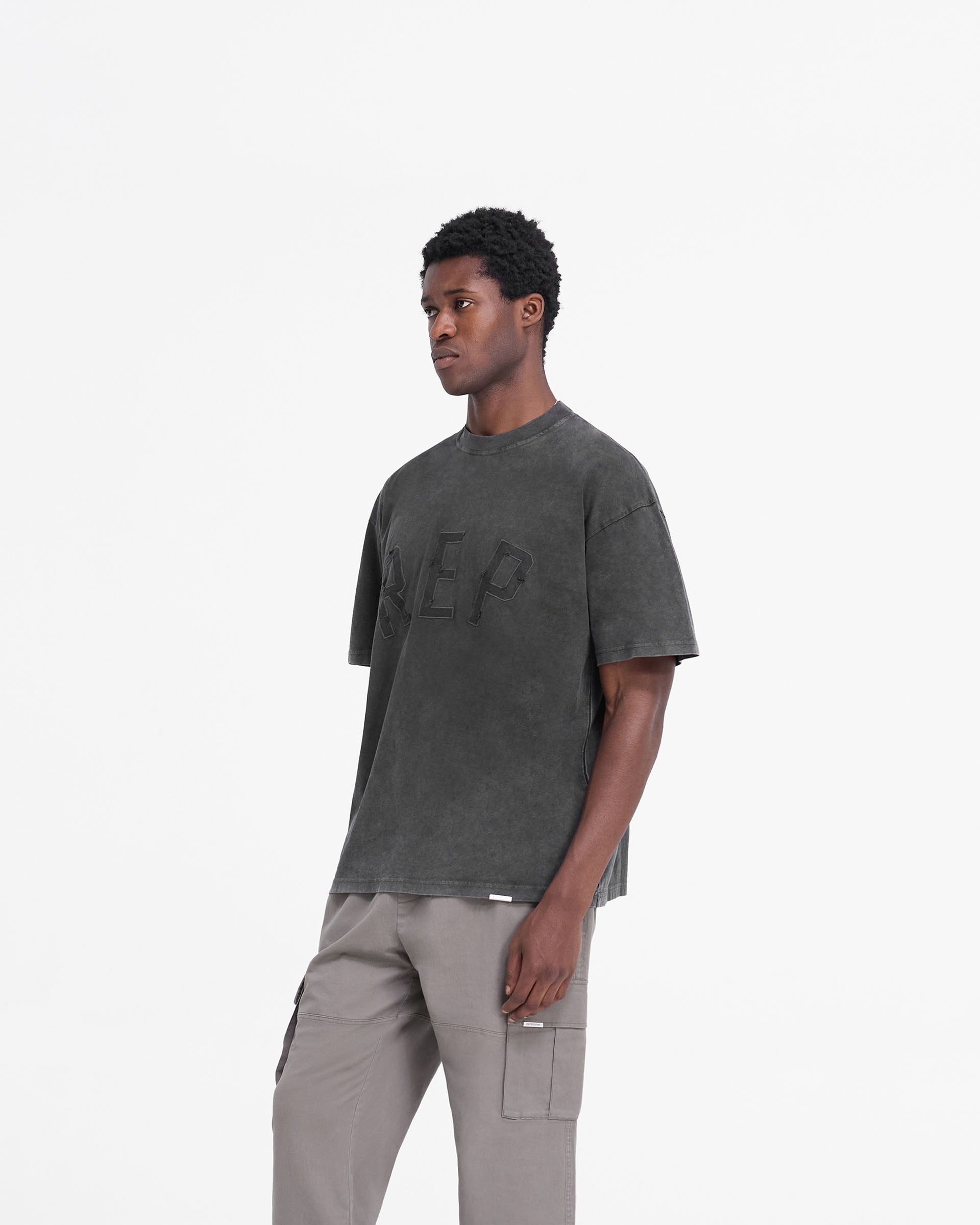 Back product image of a mens black t-shirt on a plain white background | Rep Applique T-Shirt in Vintage Black | Oversized t-shirt with distressed applique logo | FW24 T-Shirts | Represent Clo