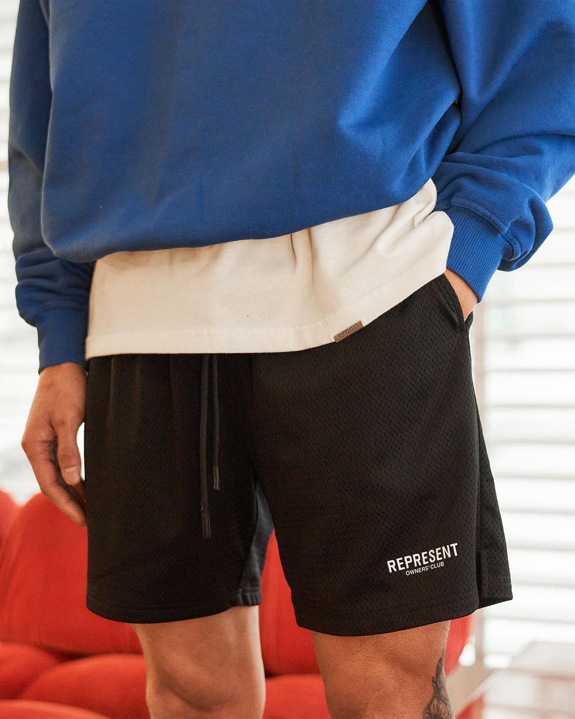 Back product image of mens black shorts on a plain white background | Represent Owners Club Mesh Shorts in Black | Relaxed fit mesh shorts with welt pockets | Owners Club Shorts | Represent Clo