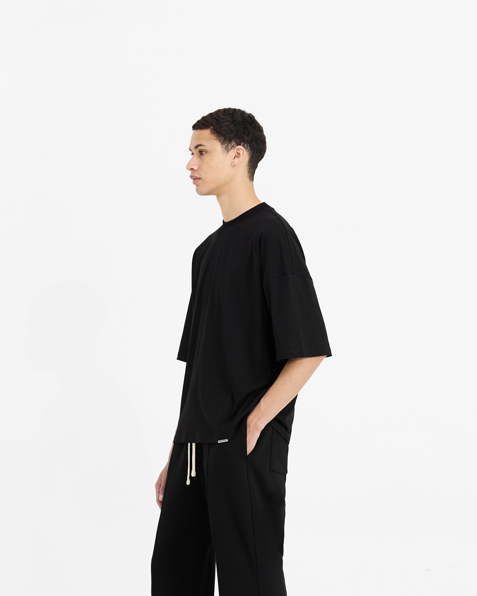Back product image of a mens black t-shirt on a plain white background | Initial Boxy T-Shirt in Black | Oversized boxy cropped t-shirt with ribbed collar | Initial T-Shirts | Represent Clo