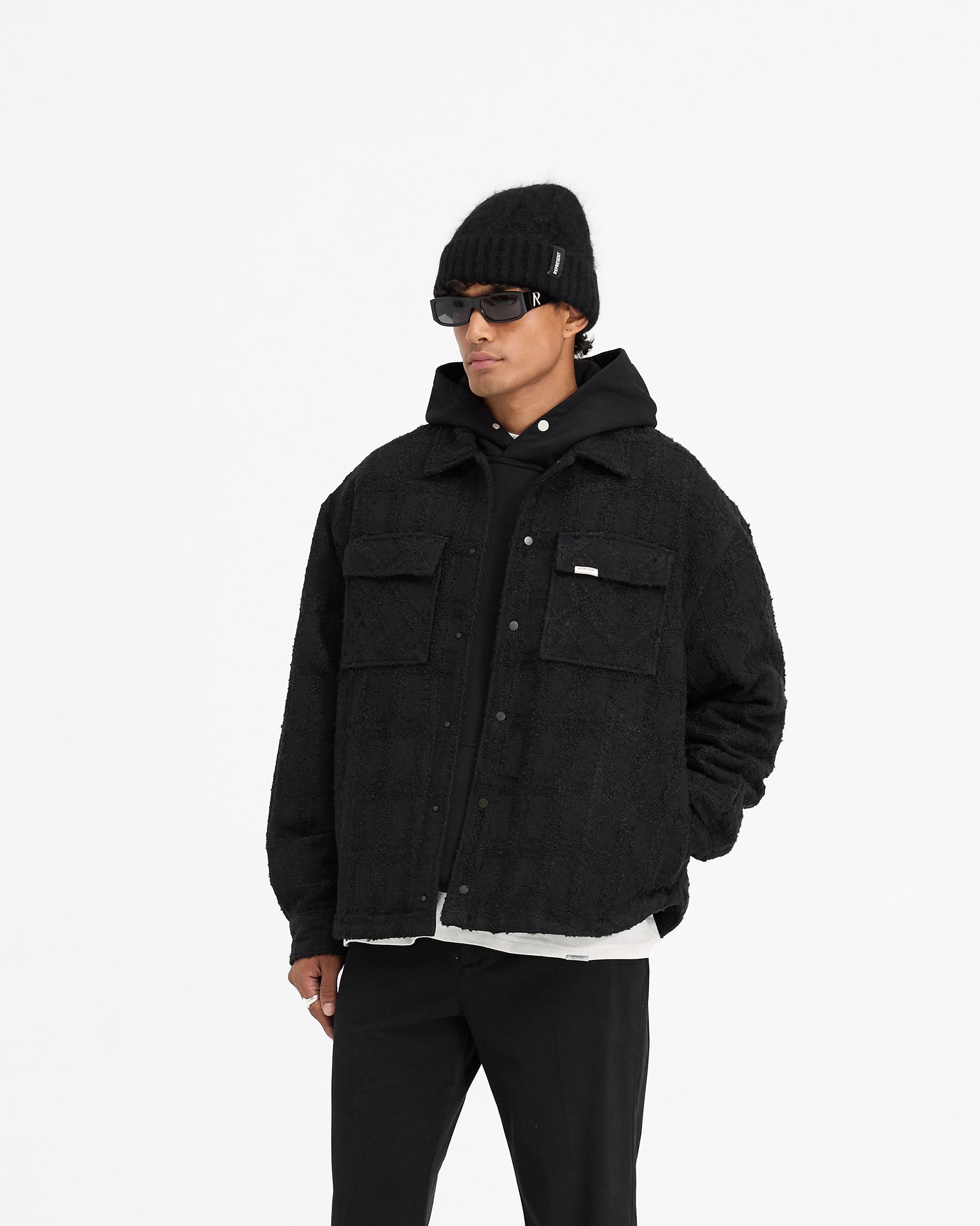 Back product image of a mens black overshirt on a plain white background | Wadded Overshirt in Black | Overshirt with matte black popper closures and flap pockets | FW24 Shirts | Represent Clo