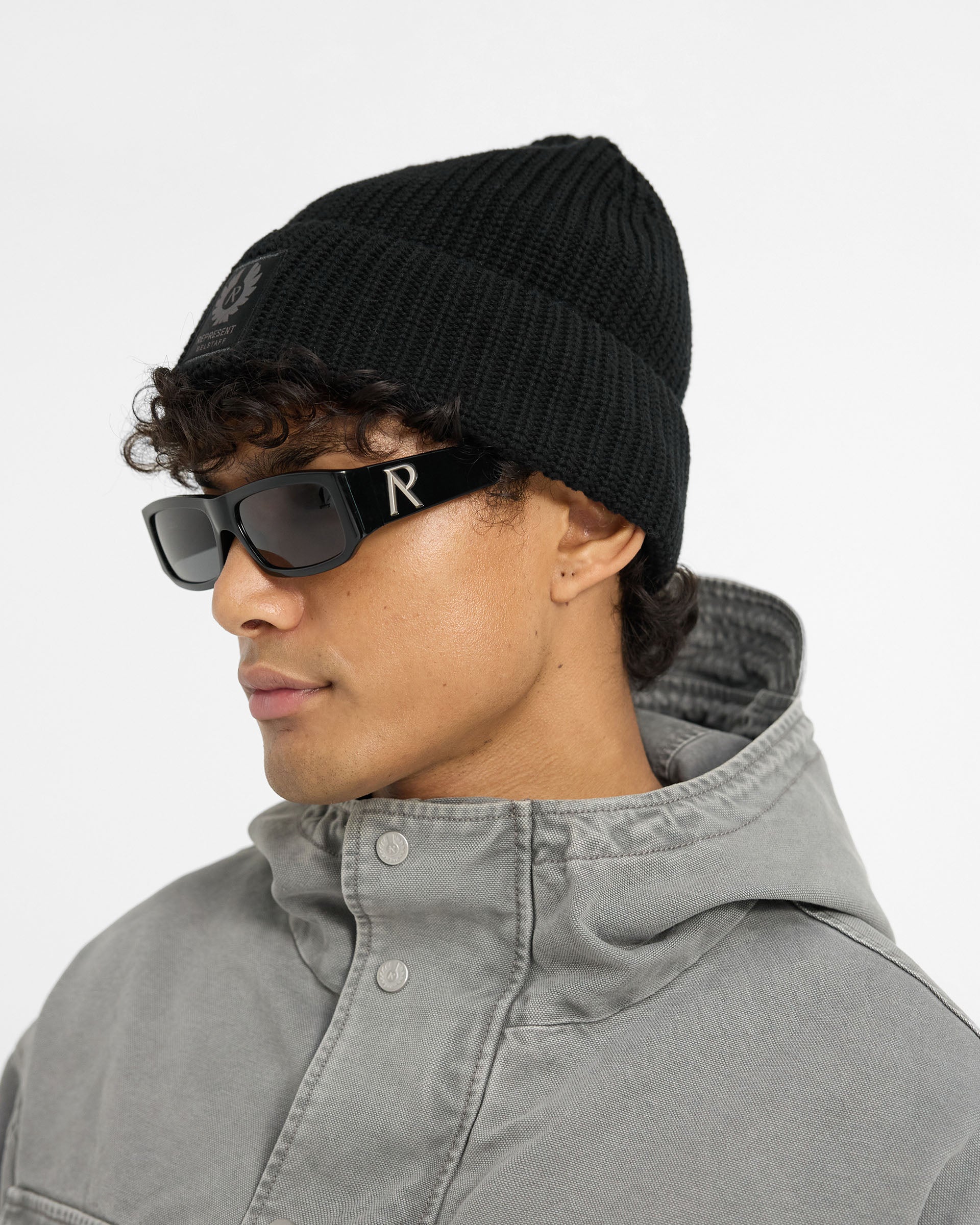 Back product image of a mens black beanie on a plain white background | Represent X Belstaff Patch Beanie in Black | Ribbed cotton beanie with woven patch logo | Exclusive Accessories | Represent Clo