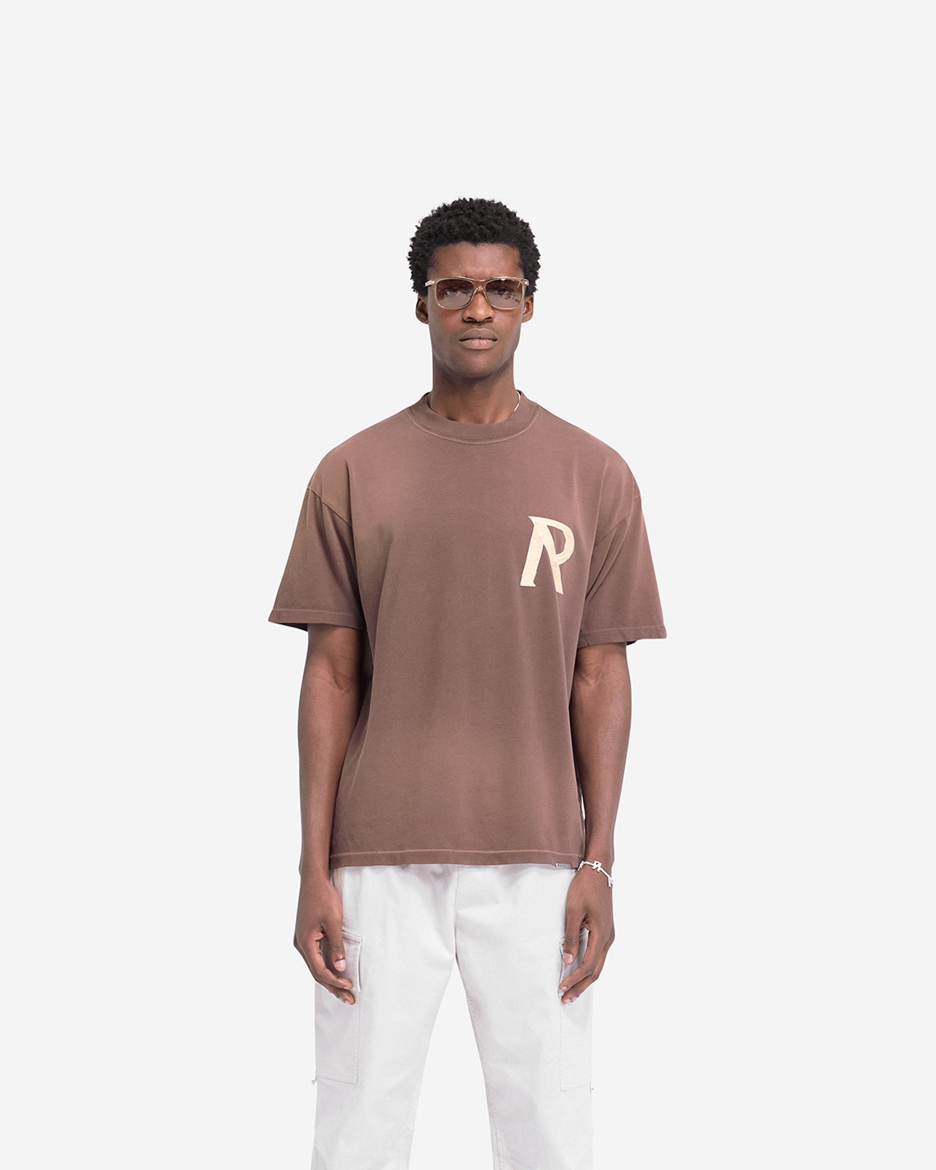 Man wearing a cedar t-shirt on a plain white background | Masking Tape Initial T-Shirt in Cedar | T-shirt with 3D masking tape effect initial | FW24 T-Shirts | Represent Clo