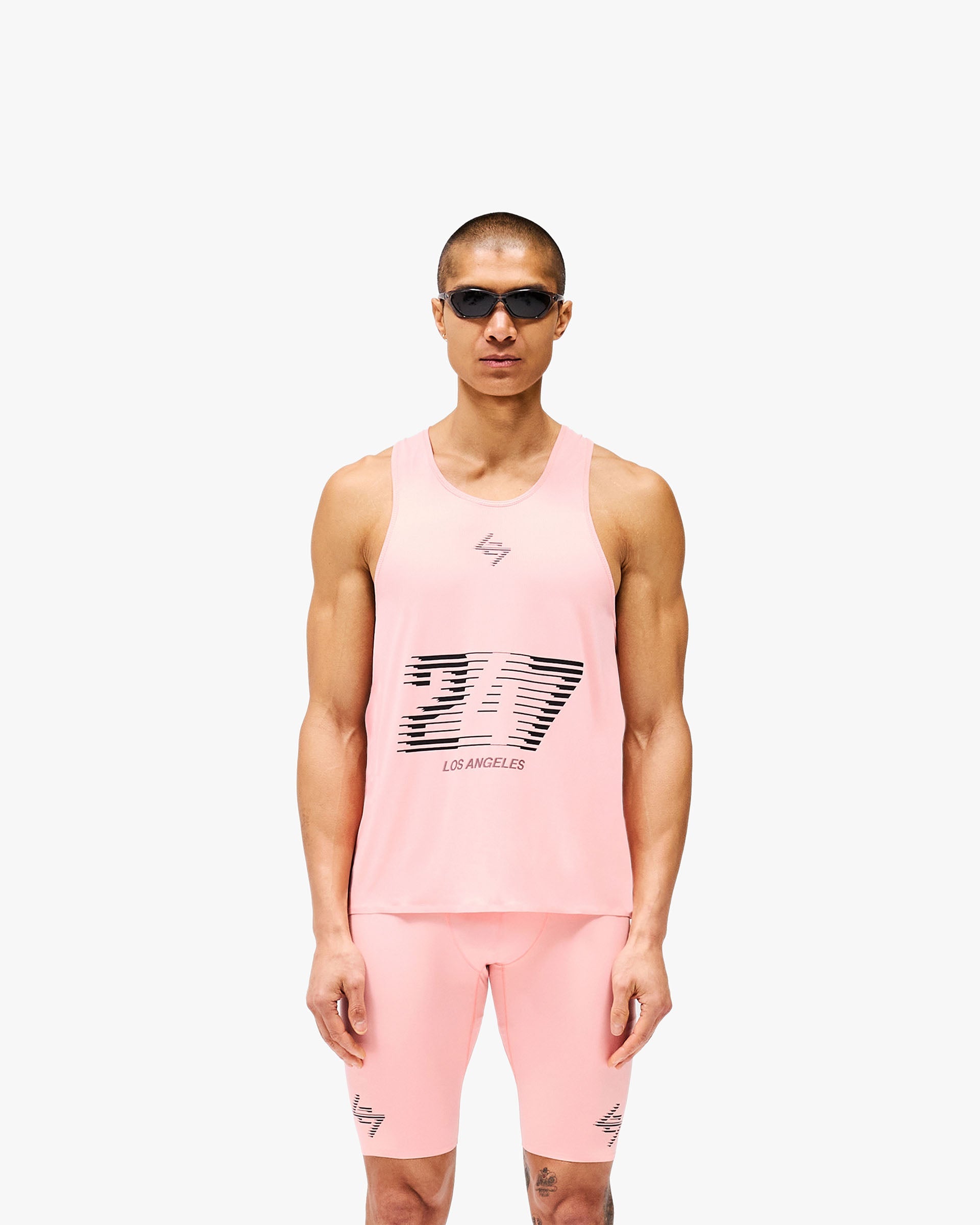 Man wearing a pink singlet on a plain white background | 247 Los Angeles Singlet in Pink | Lightweight breathable racerback singlet with mesh back | 247 T-Shirts | Represent Clo