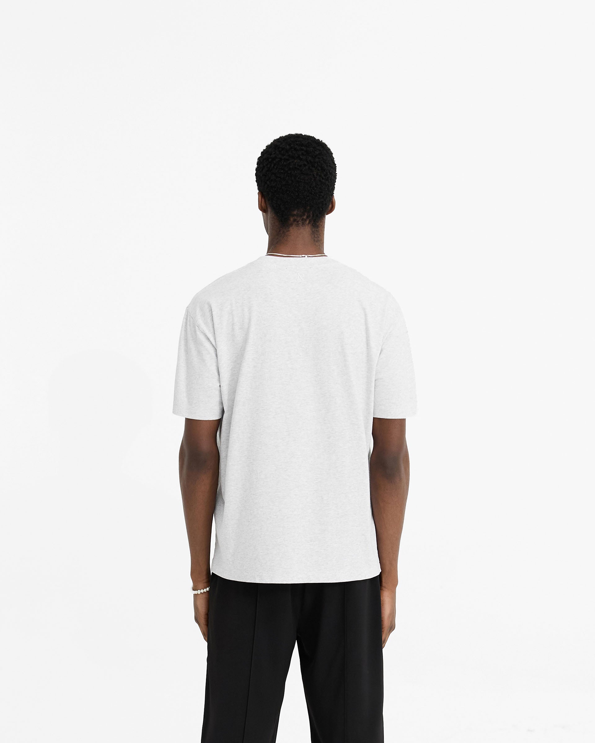 Man wearing a grey t-shirt on a plain white background | Initial T-Shirt in Ice Grey Marl | Regular fit t-shirt with embroidered details | Initial T-Shirts | Represent Clo