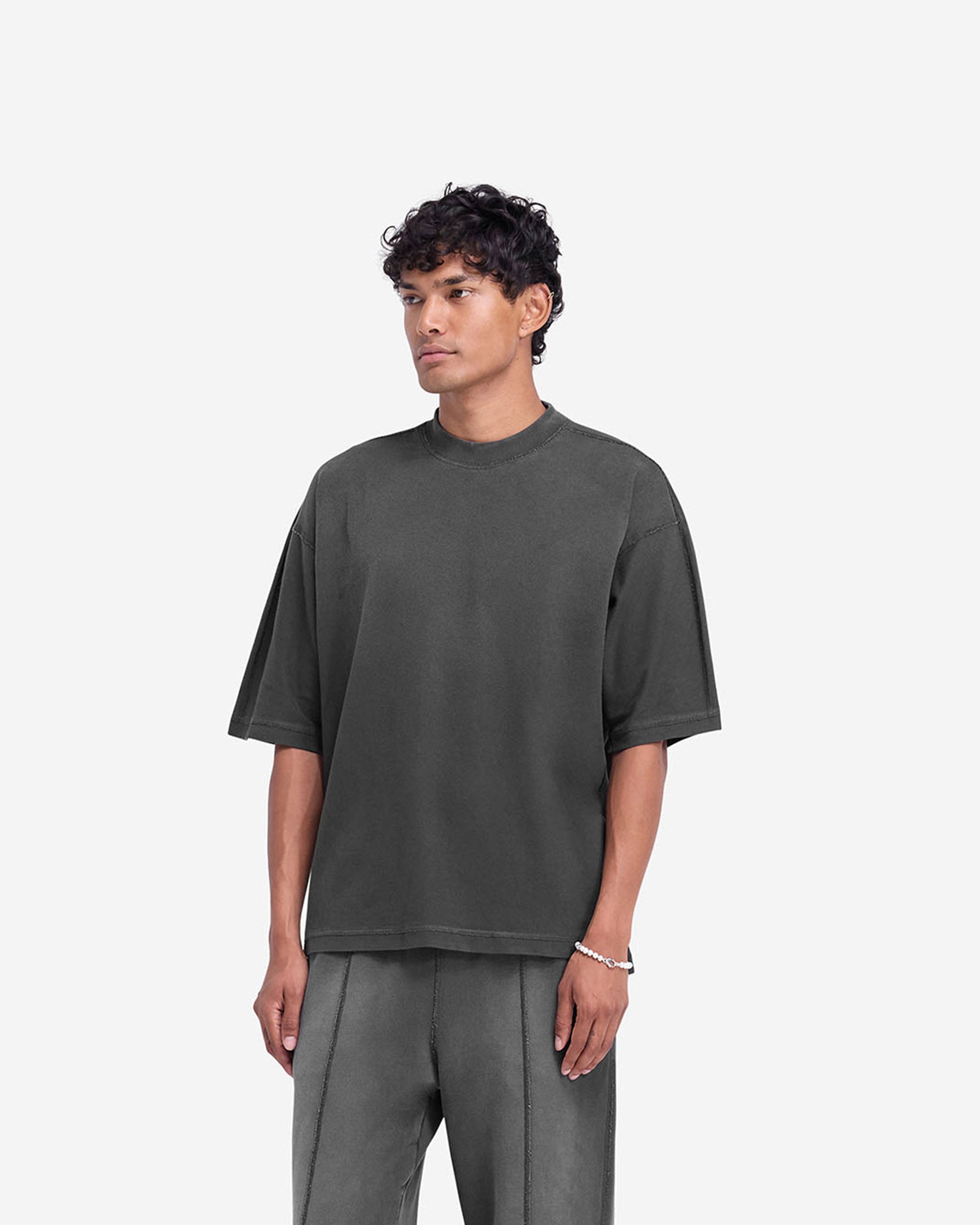 Man wearing a black t-shirt on a plain white background | Stepped Hem T-Shirt in Stained Black | Oversized t-shirt with split stepped hem | FW24 T-Shirts | Represent Clo