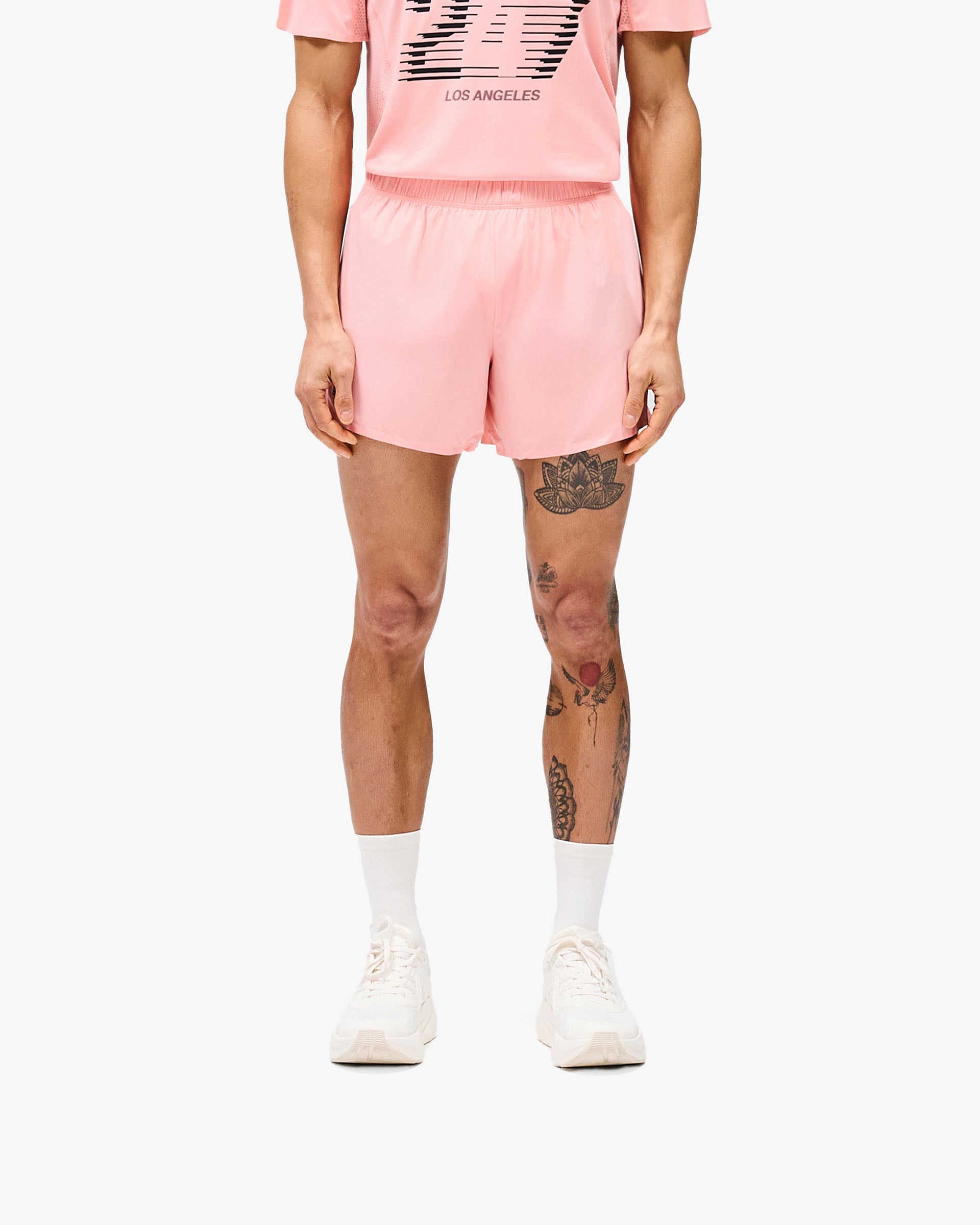 Man wearing pink shorts on a plain white background | 247 Los Angeles Shorts in Pink | Lightweight breathable running shorts with technical storage | 247 Shorts | Represent Clo