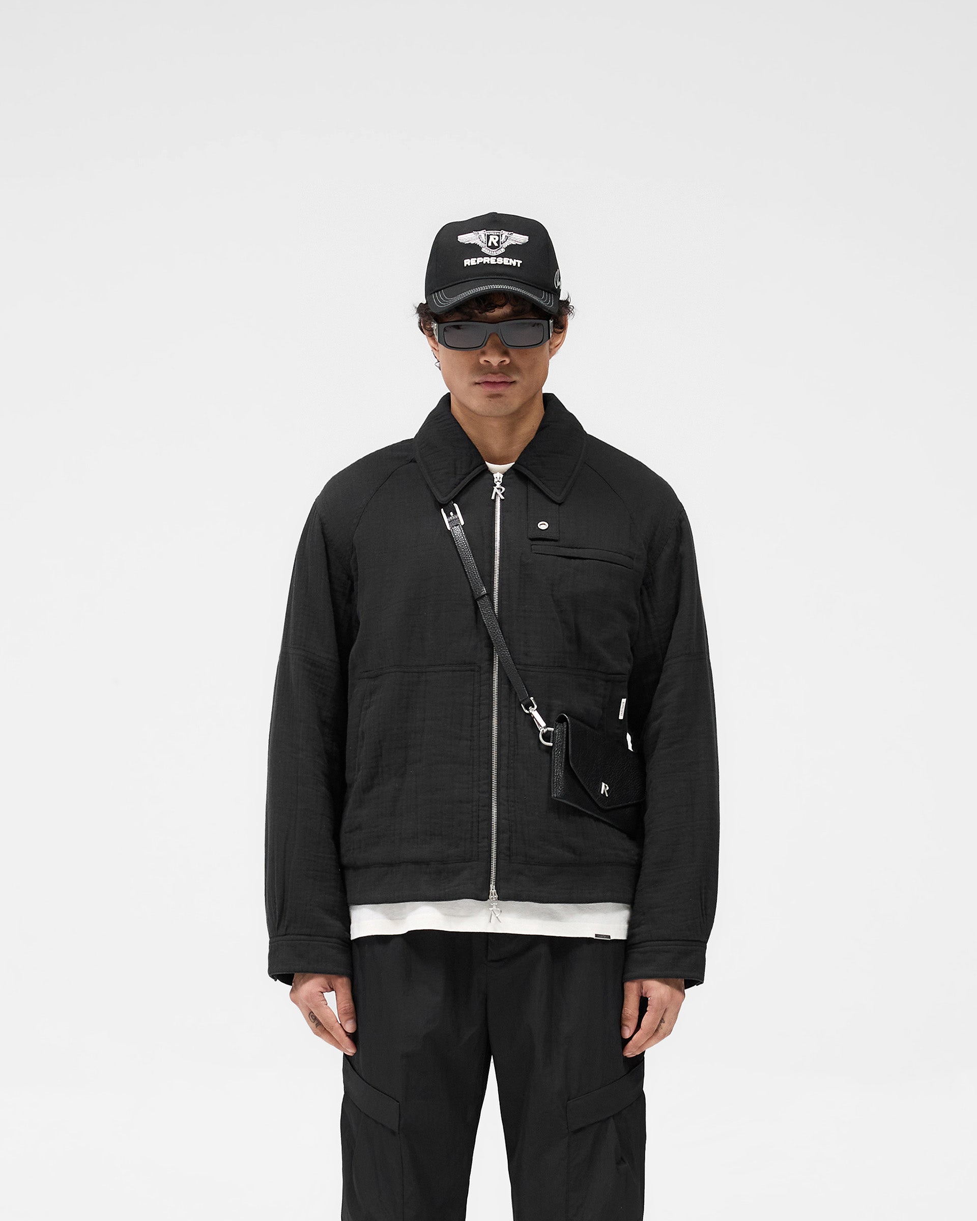 Man wearing a black jacket on a plain white background | Crinkle Trucker Jacket in Black | Cotton trucker jacket with oversized collar | SS25 Outerwear | Represent Clo