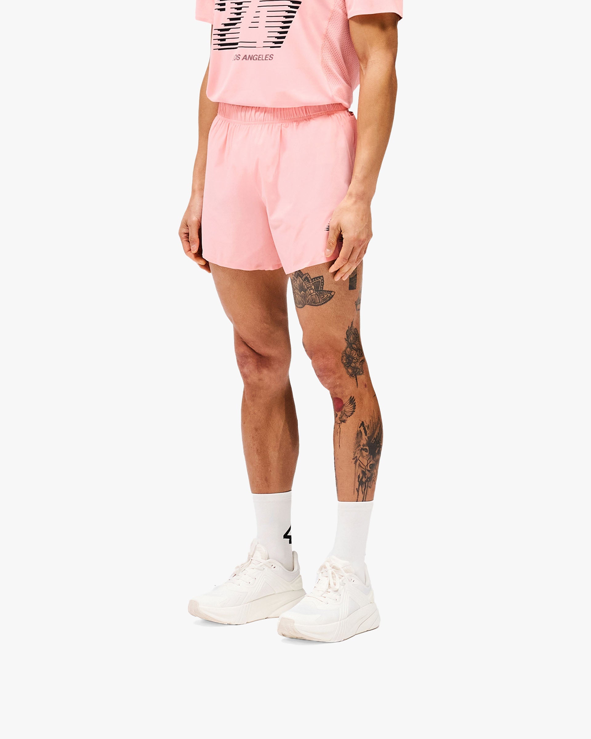 Man wearing pink shorts on a plain white background | 247 Los Angeles Shorts in Pink | Lightweight breathable shorts with internal liner and storage pouches | 247 Shorts | Represent Clo