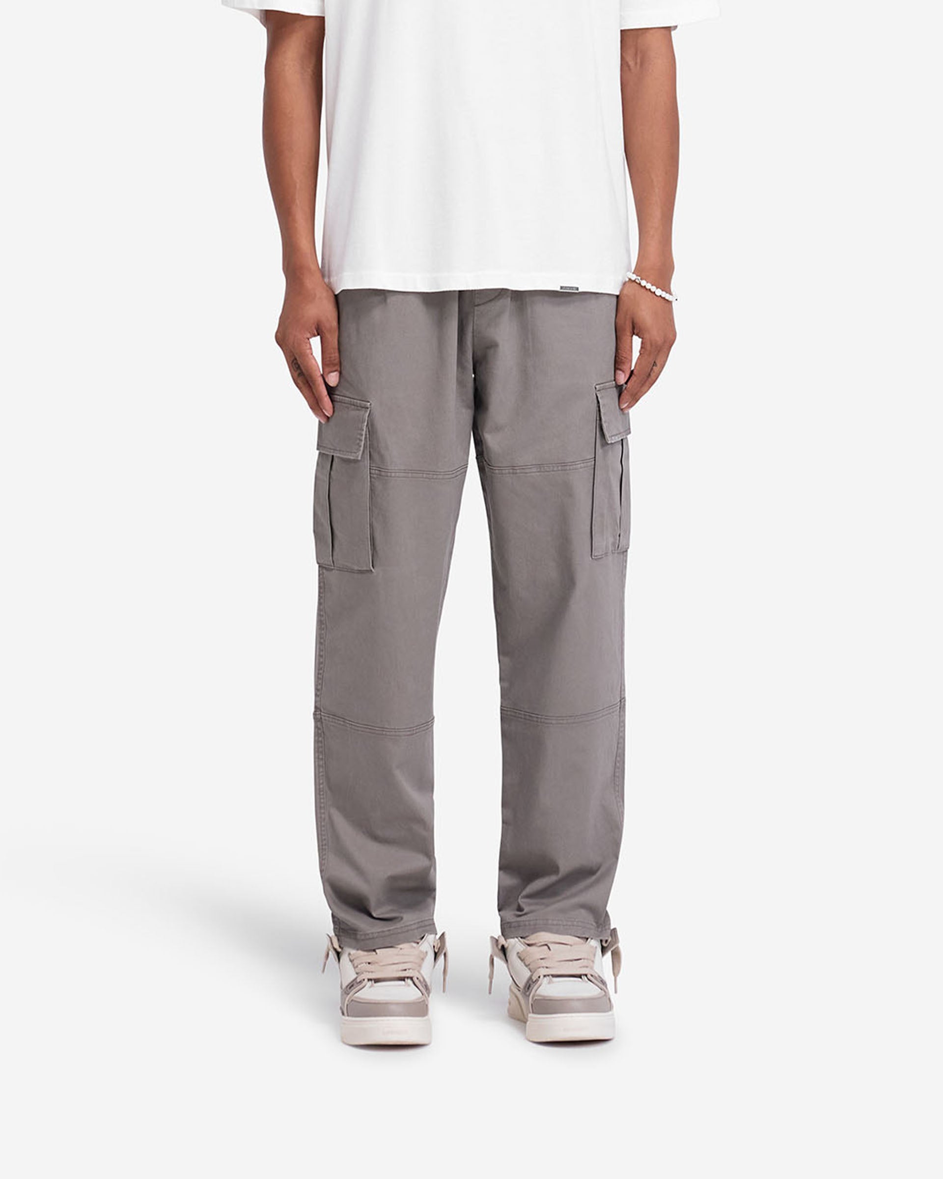 Man wearing dark taupe cargo pants on a plain white background | Cargo Pant in Dark Taupe | Cargo pants with flap pockets and elasticated waistband | FW24 Pants | Represent Clo