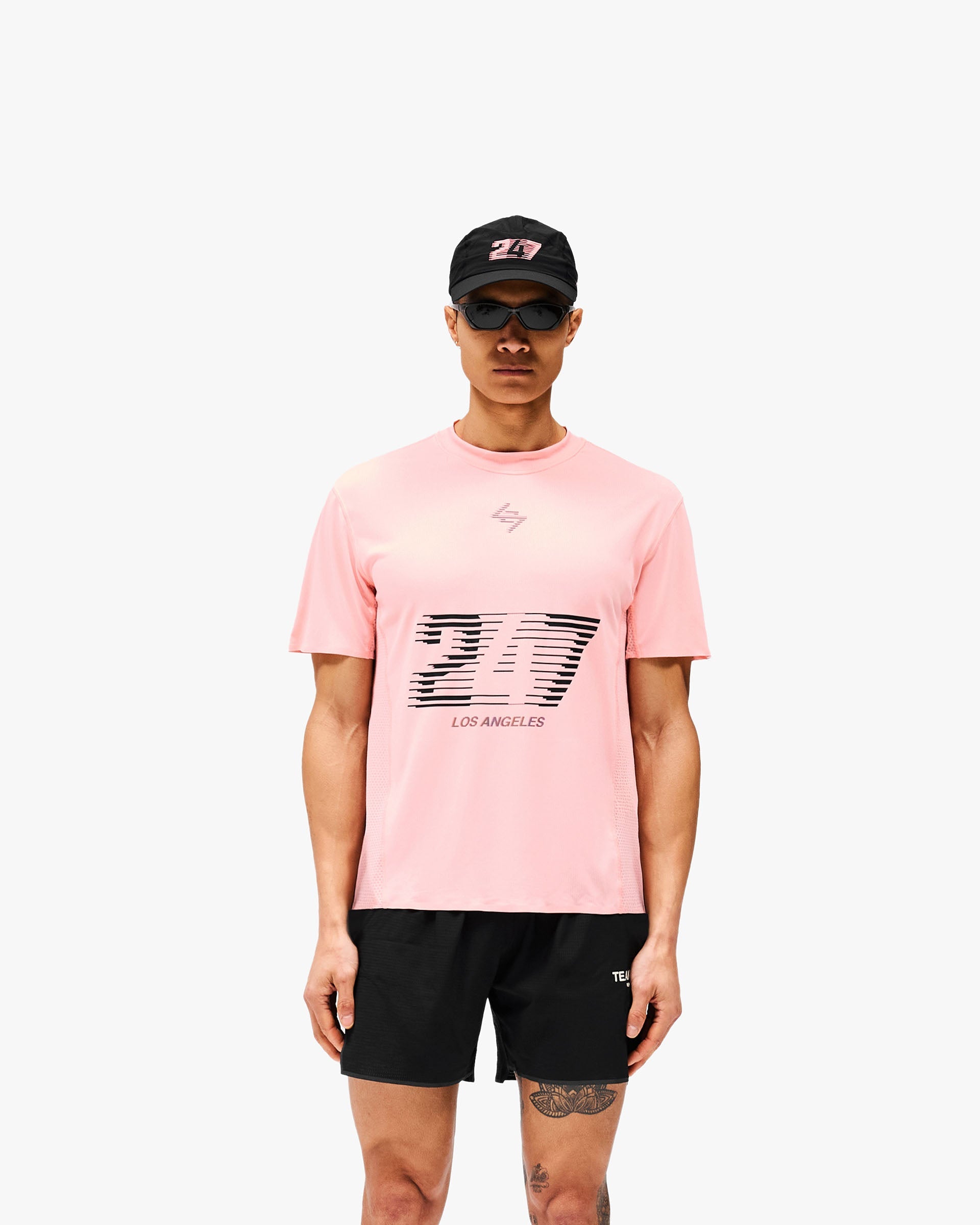 Man wearing a pink t-shirt on a plain white background | 247 Los Angeles T-Shirt in Pink | Lightweight sweat-wicking t-shirt with honeycomb mesh panelling | 247 T-Shirts | Represent Clo