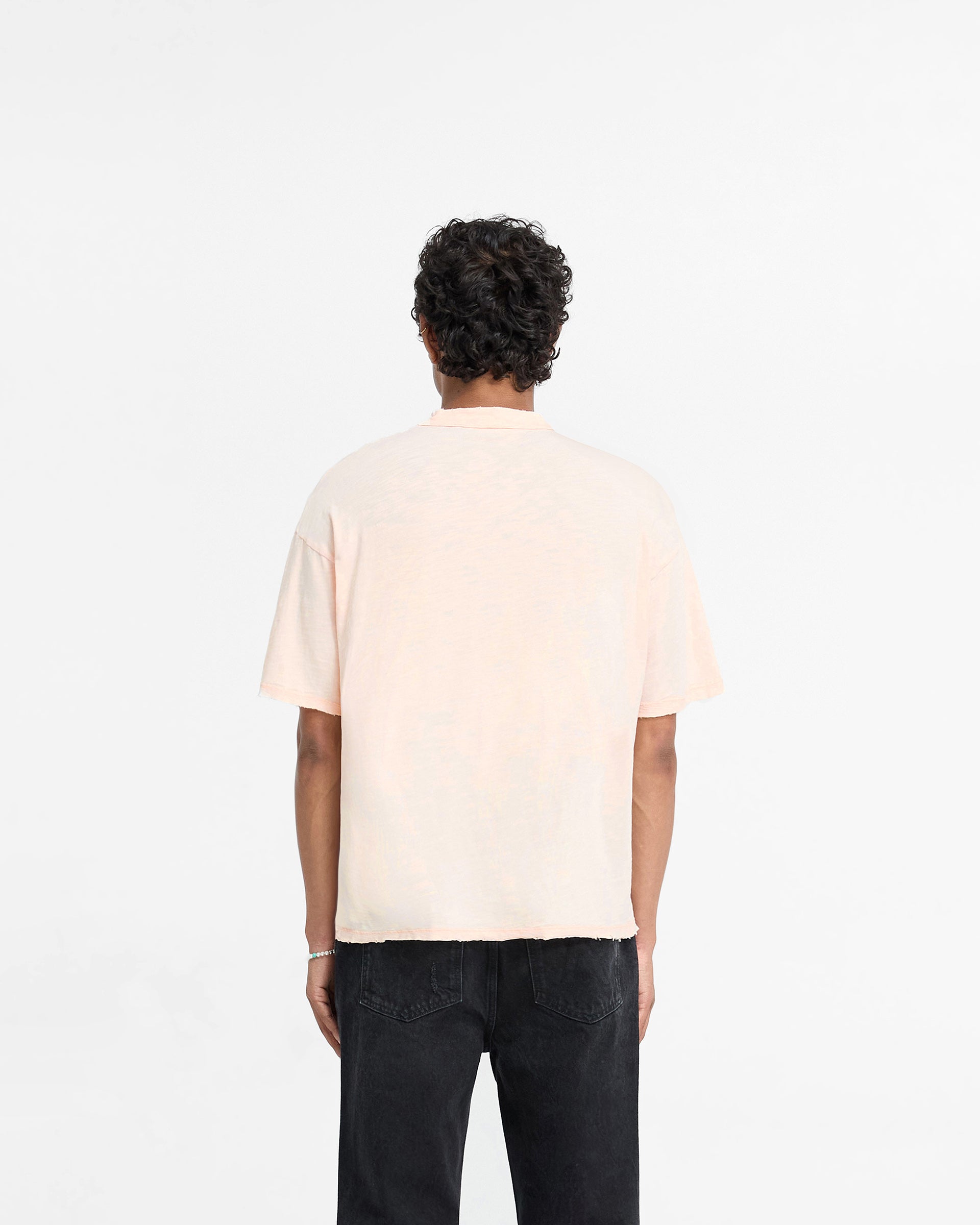 Man wearing a coral t-shirt on a plain white background | Slub T-Shirt in Washed Coral | Oversized cotton t-shirt with tonal embroidery | FW24 T-Shirts | Represent Clo