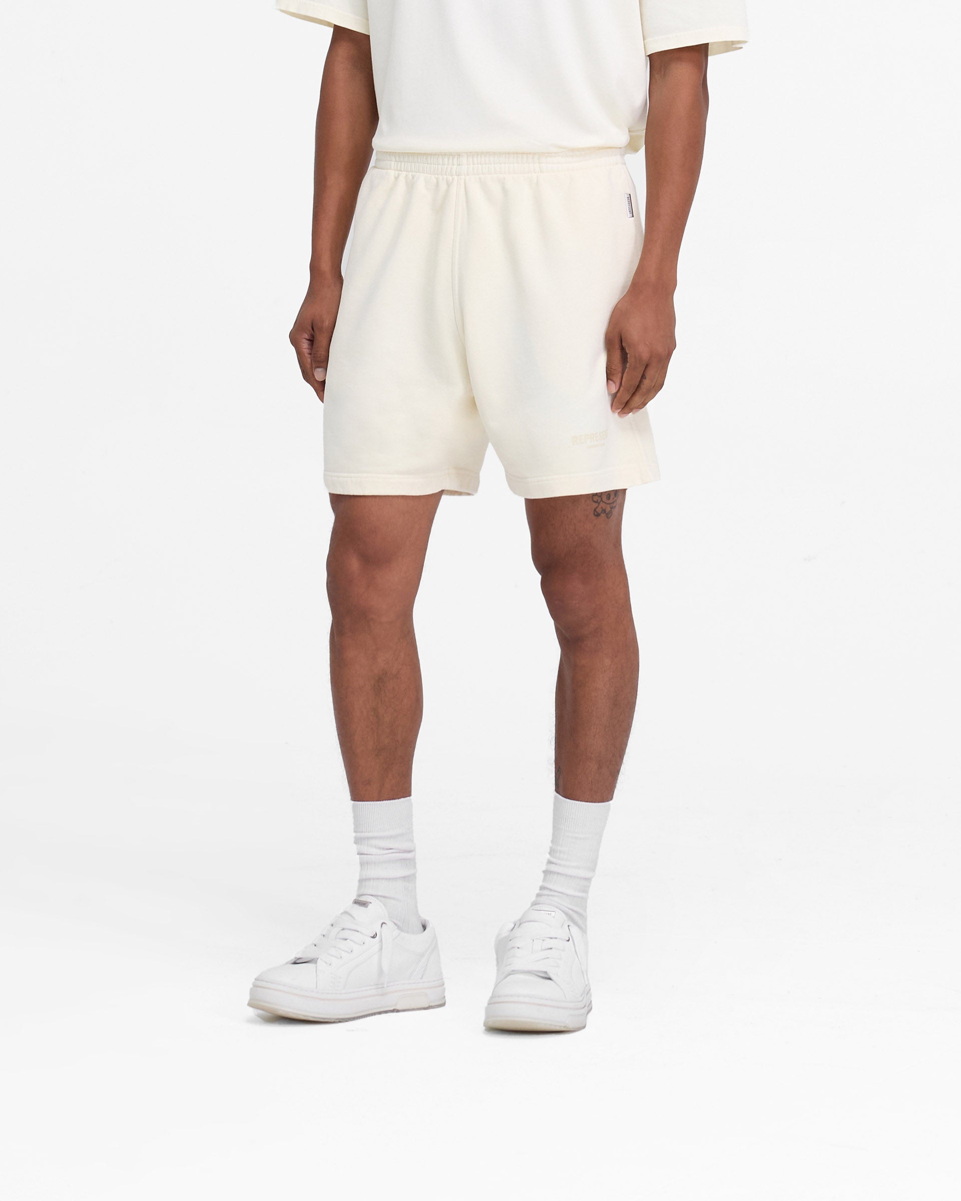 Back product image of mens cream shorts on a plain white background | Represent Owners Club Shorts in Buttercream | Relaxed fit shorts with elasticated waistband | Owners Club Shorts | Represent Clo