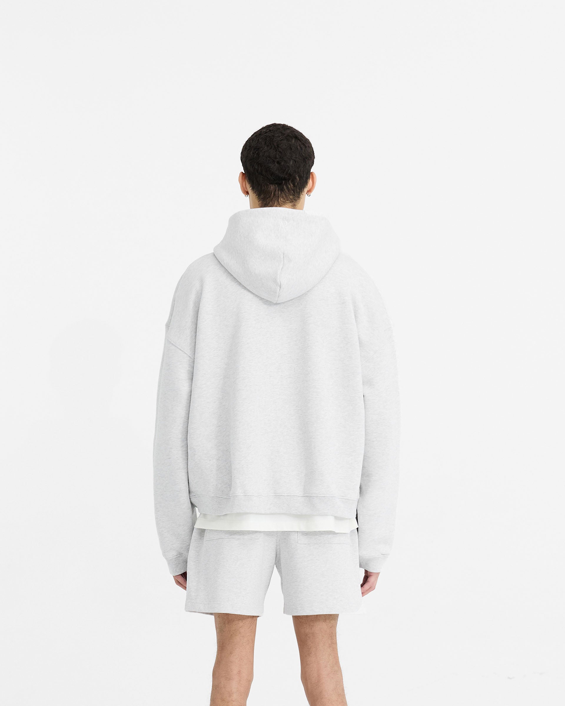 Man wearing a grey zip hoodie on a plain white background | Initial Boxy Zip Through Hoodie in Ice Grey Marl | Oversized boxy fit cropped hoodie | Initial Hoodies | Represent Clo