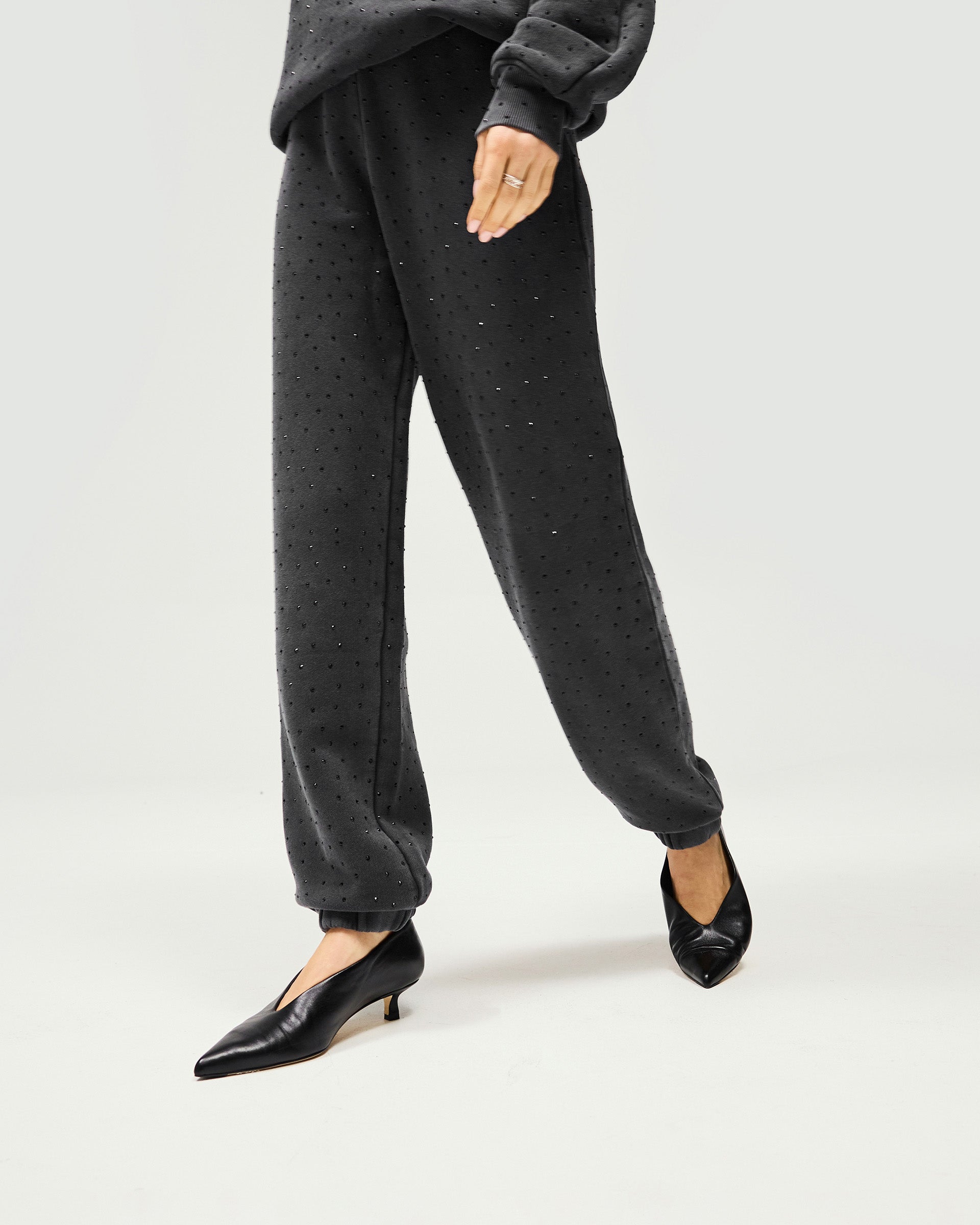 Woman wearing washed grey trackpants on a plain white background | Spark Trackpant in Washed Grey | Heavy hotfix jogger style, relaxed fit | Womens SS25 Bottoms | Represent Clo
