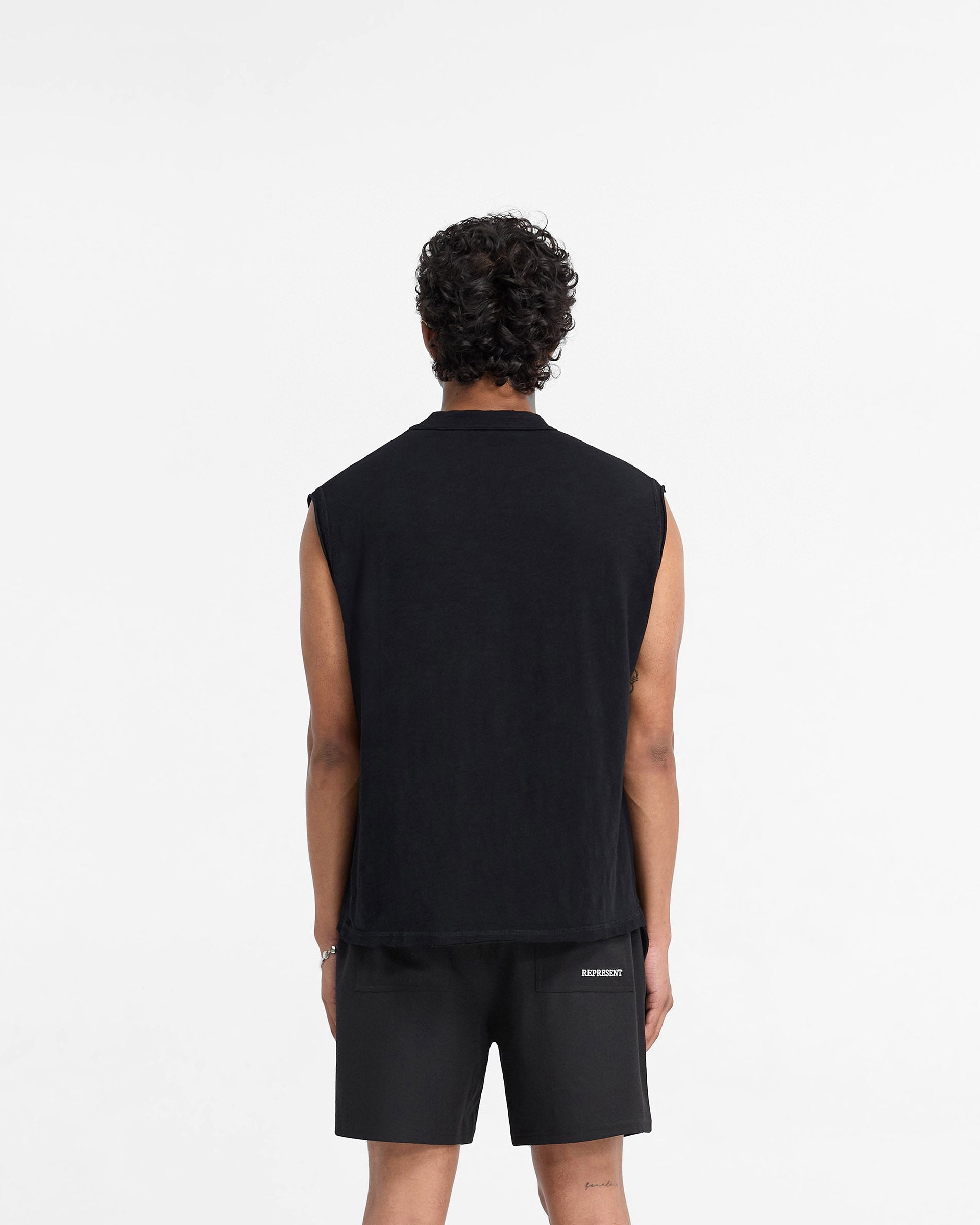 Man wearing a black tank top on a plain white background | Slub Tank in Jet Black | Oversized tank top with distressed details | FW24 T-Shirts | Represent Clo