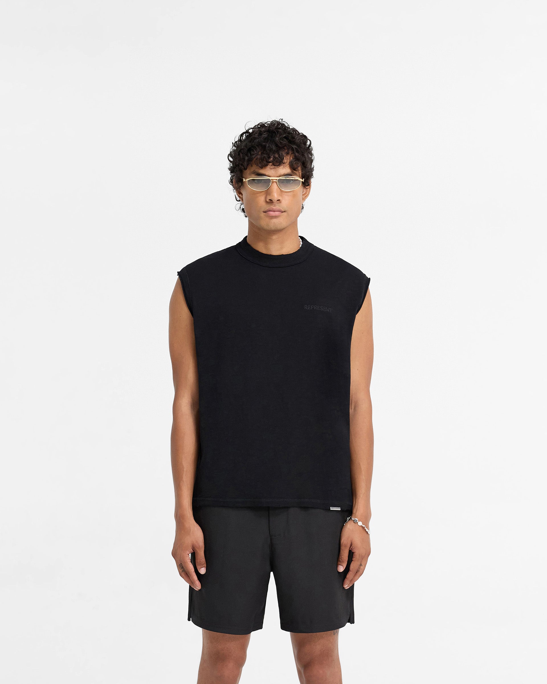 Man wearing a black tank top on a plain white background | Slub Tank in Jet Black | Oversized fit tank with tonal embroidery | FW24 T-Shirts | Represent Clo