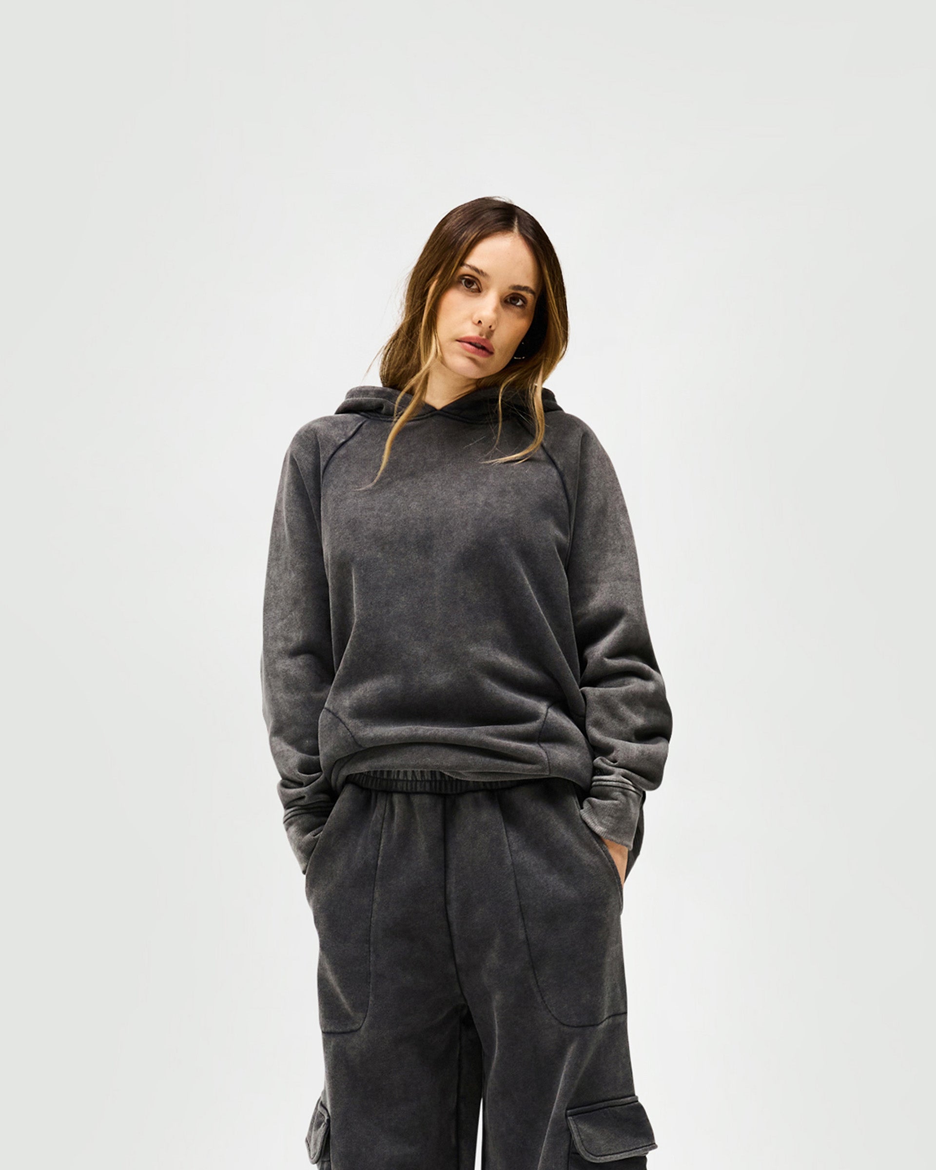 Woman wearing a charcoal oversized hoodie on a plain white background | Monster Hoodie in Charcoal | Oversized fit with dropped sleeves and embroidered branding | Womens SS25 Hoodies | Represent Clo