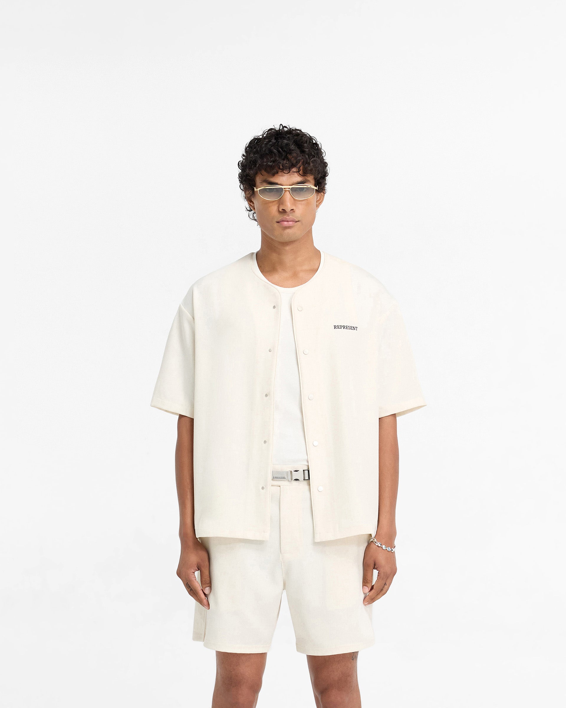 Man wearing a white baseball shirt on a plain white background | Baseball Shirt in Antique White | Collarless shirt with popper button up | FW24 Shirts | Represent Clo