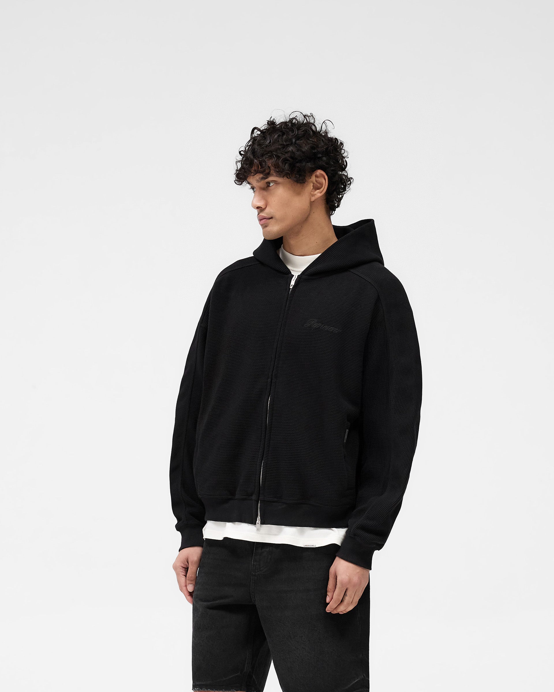 Back product image of a mens black hoodie on a plain white background | Waffle Zip Through Hoodie in Jet Black | Boxy fit hoodie with branded RiRi zipper | SS25 Hoodies | Represent Clo