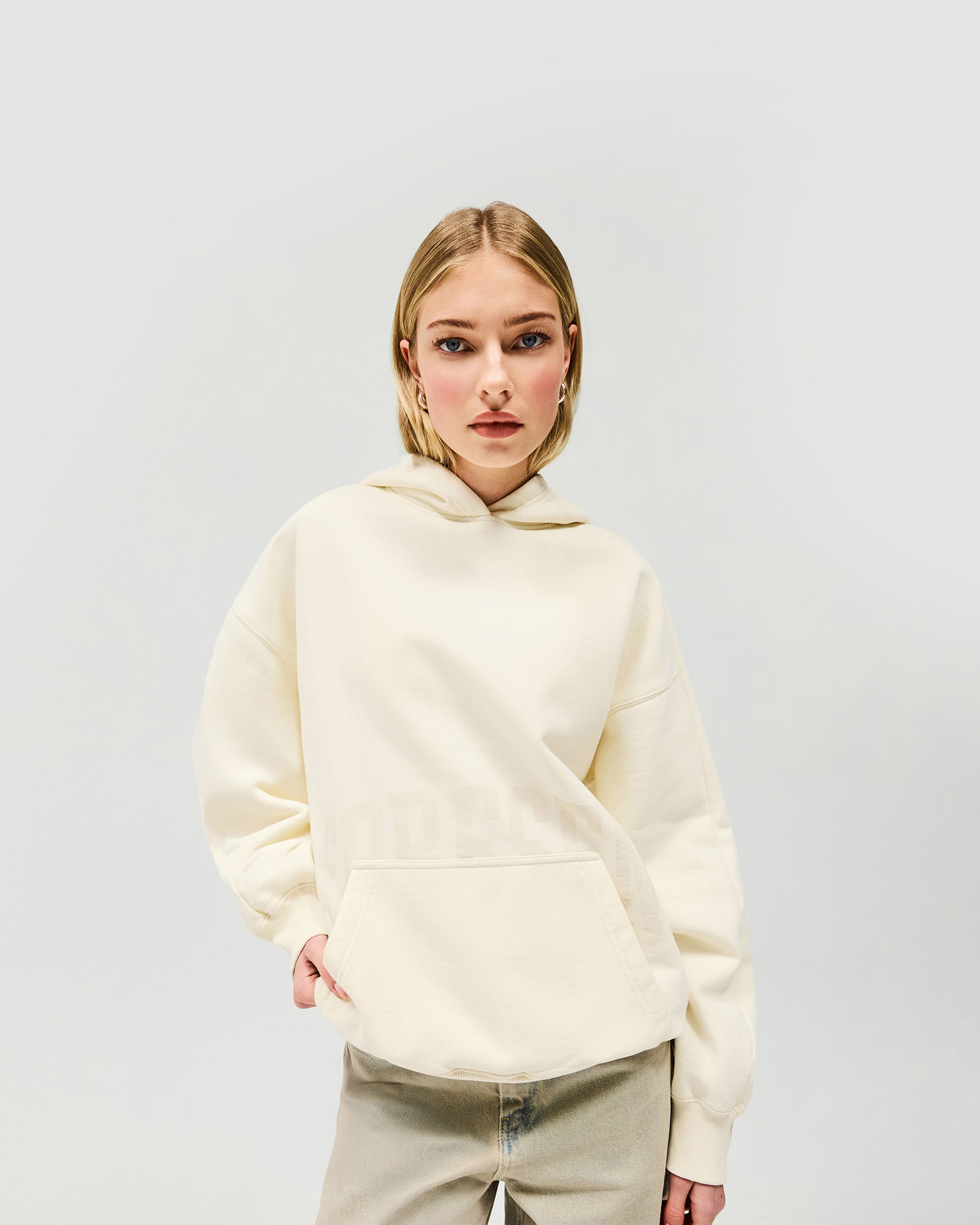 Woman wearing an oversized cream hoodie on a plain white background | Boyfriend Graphic Hoodie in Cream | Mid weight relaxed fit oversized hoodie | Womens SS25 Hoodies | Represent Clo