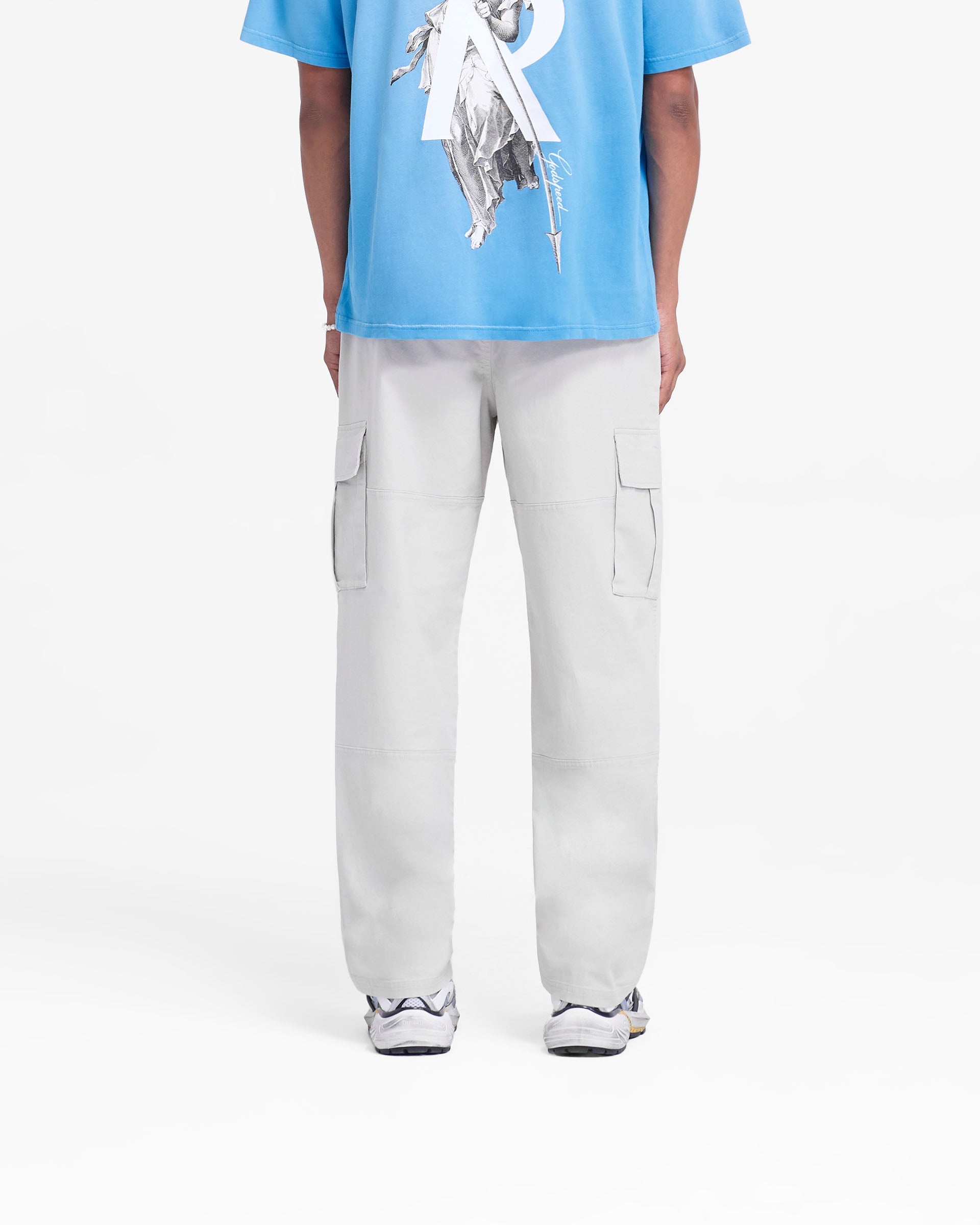 Man wearing stone cargo pants on a plain white background | Cargo Pant in Stone | Cargo pants with elasticated waistband and flap pockets | FW24 Pants | Represent Clo
