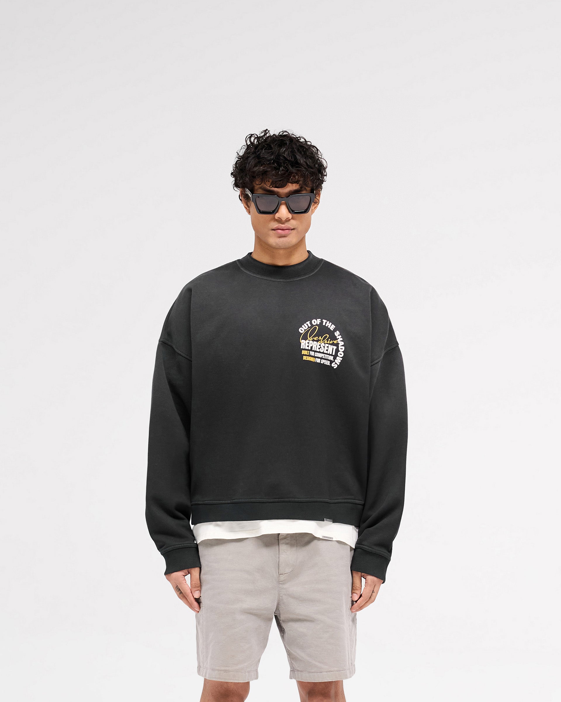 Man wearing a black sweater on a plain white background | Out Of The Shadows Sweater in Stained Black | Boxy fit sweater with fade-out wash | SS25 Sweaters | Represent Clo