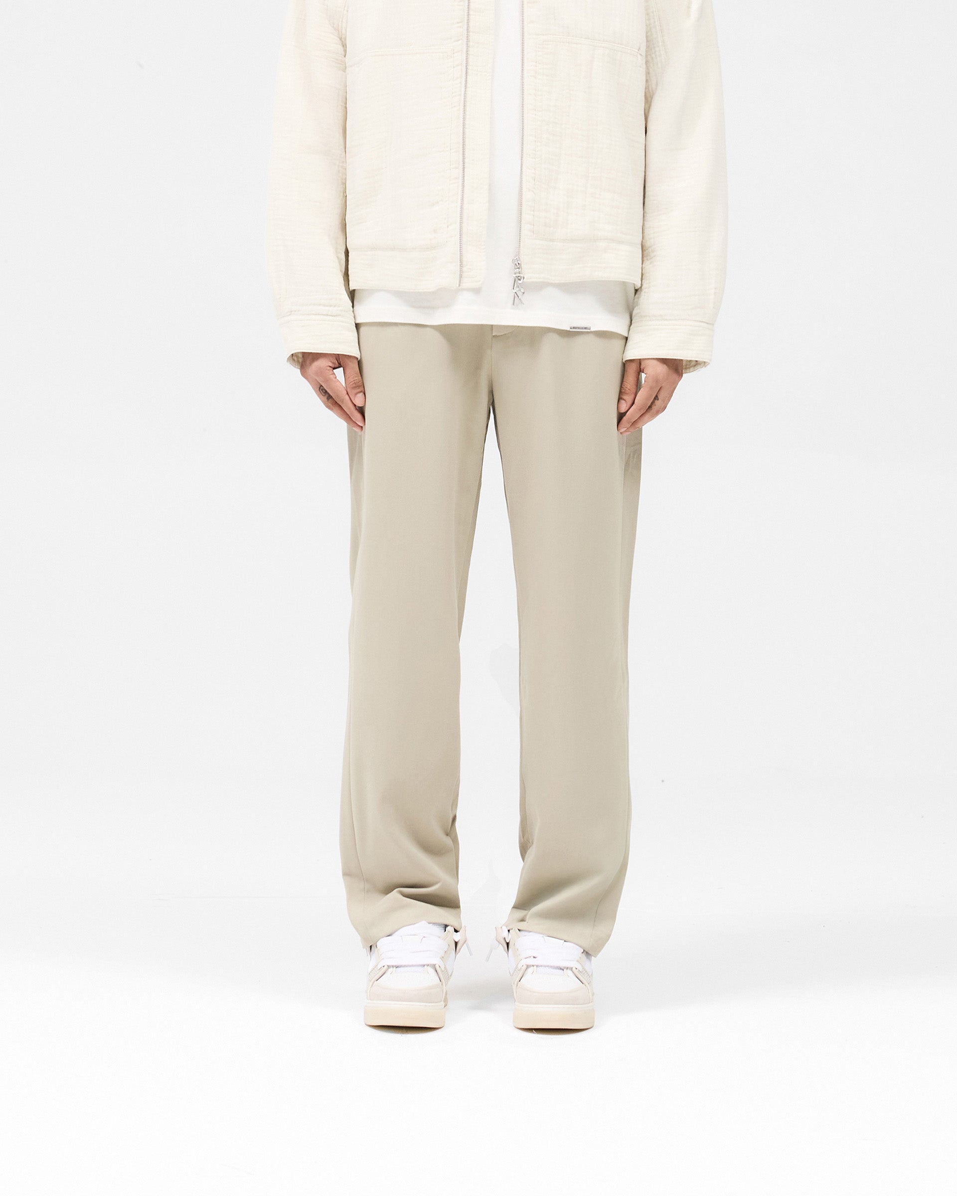 Man wearing light grey pants on a plain white background | Core Pant in Light Grey | Pants with hybrid-style waistband and elasticated section | SS25 Pants | Represent Clo