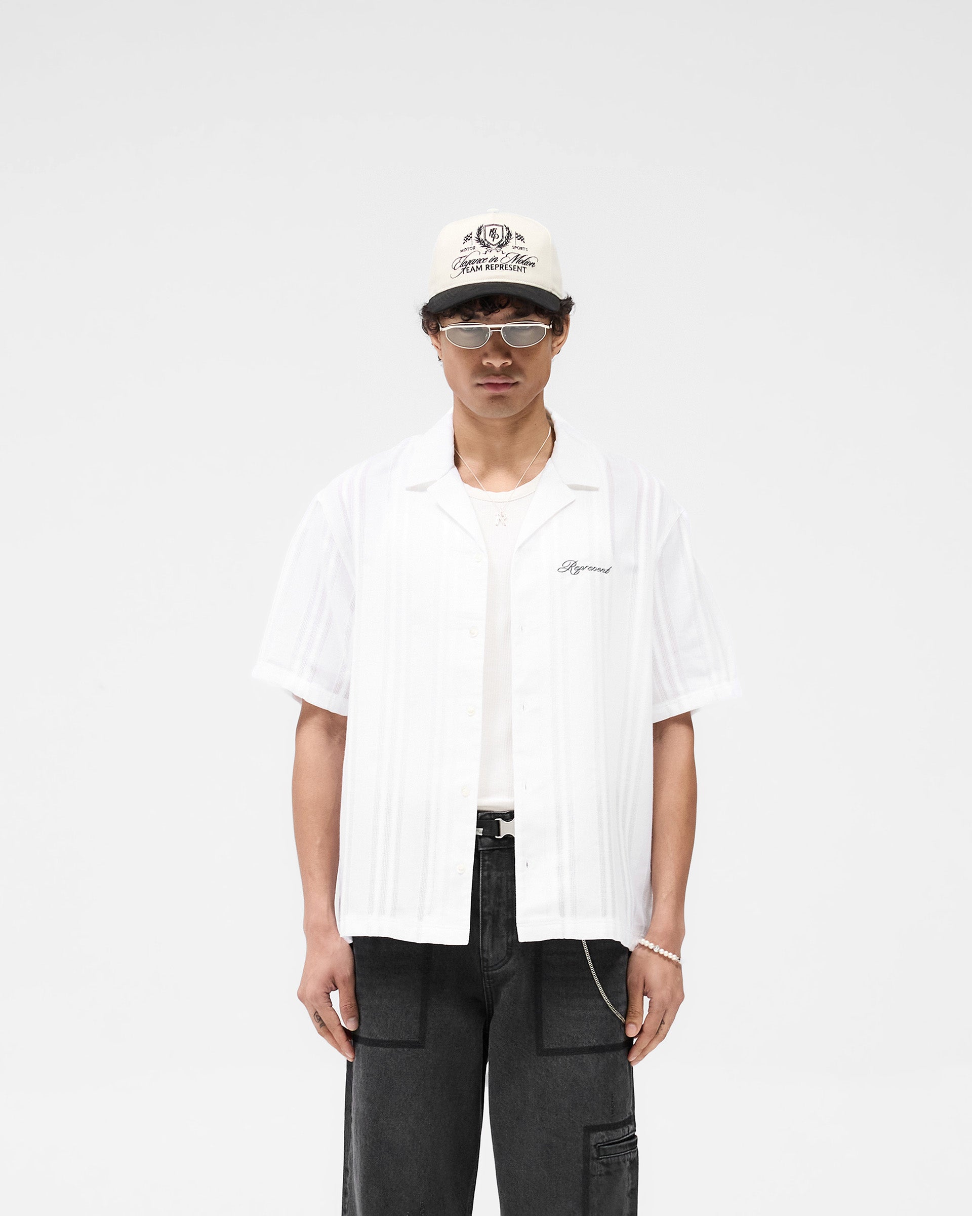 Man wearing an antique white shirt on a plain white background | Embroidered Bowling Shirt in Antique White | Sheer fabric with panelled detailing | SS25 Shirts | Represent Clo