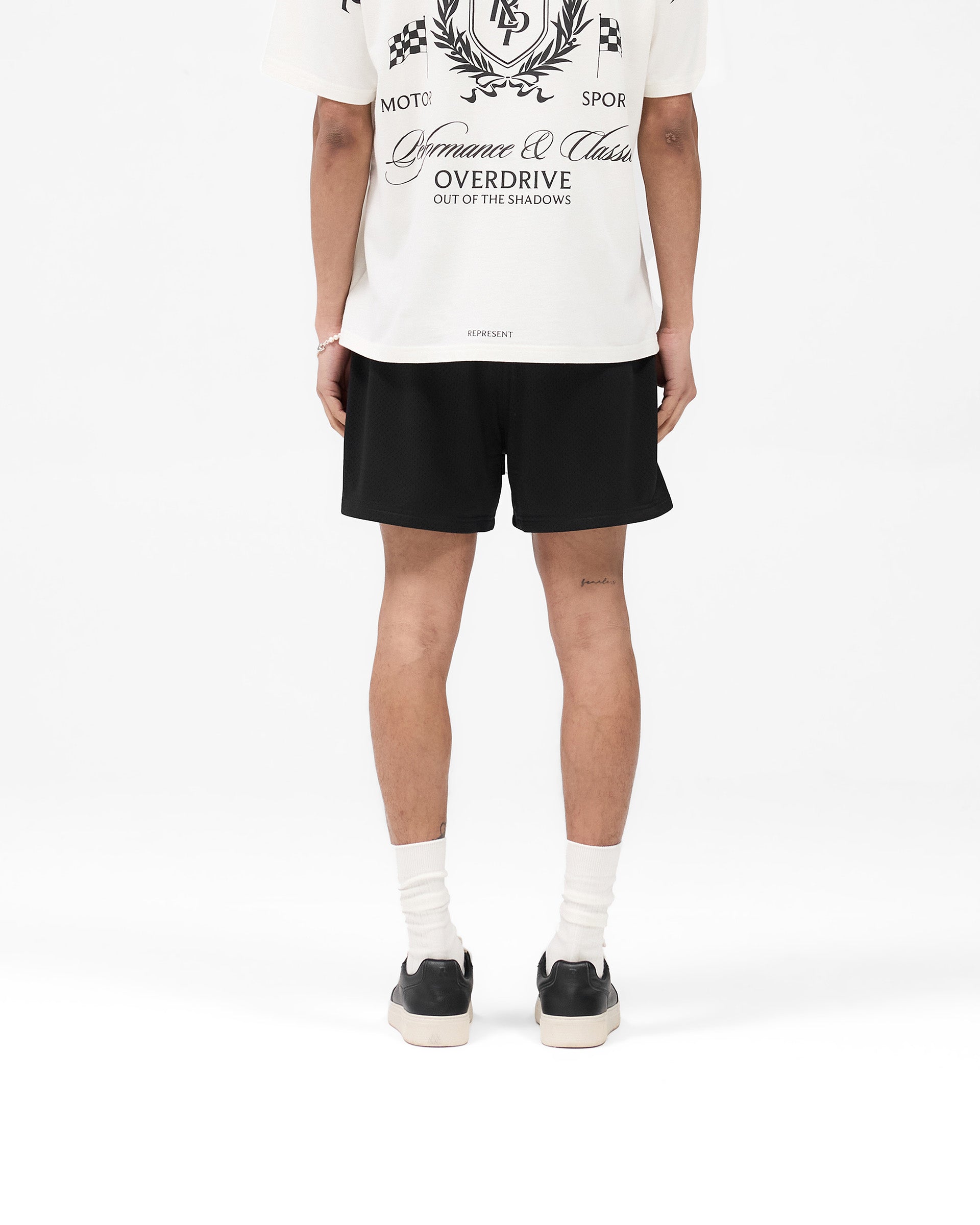 Man wearing black mesh shorts on a plain white background | Mesh Short in Black | Mesh shorts with internal drawcord and side pockets | SS25 Shorts | Represent Clo