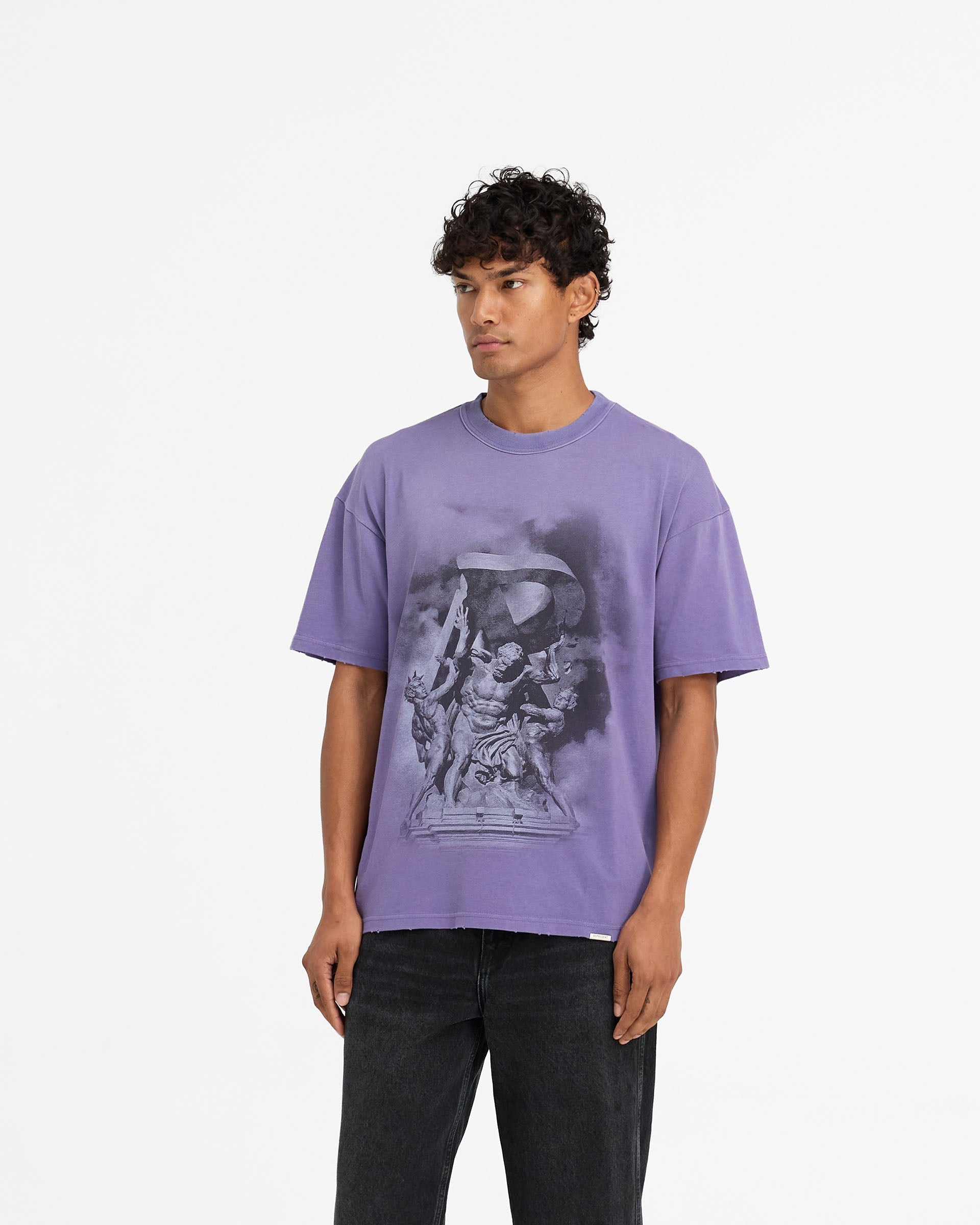 Man wearing a purple t-shirt on a plain white background | Atlas T-Shirt in Purple | Slightly oversized t-shirt with distressed details | FW24 T-Shirts | Represent Clo
