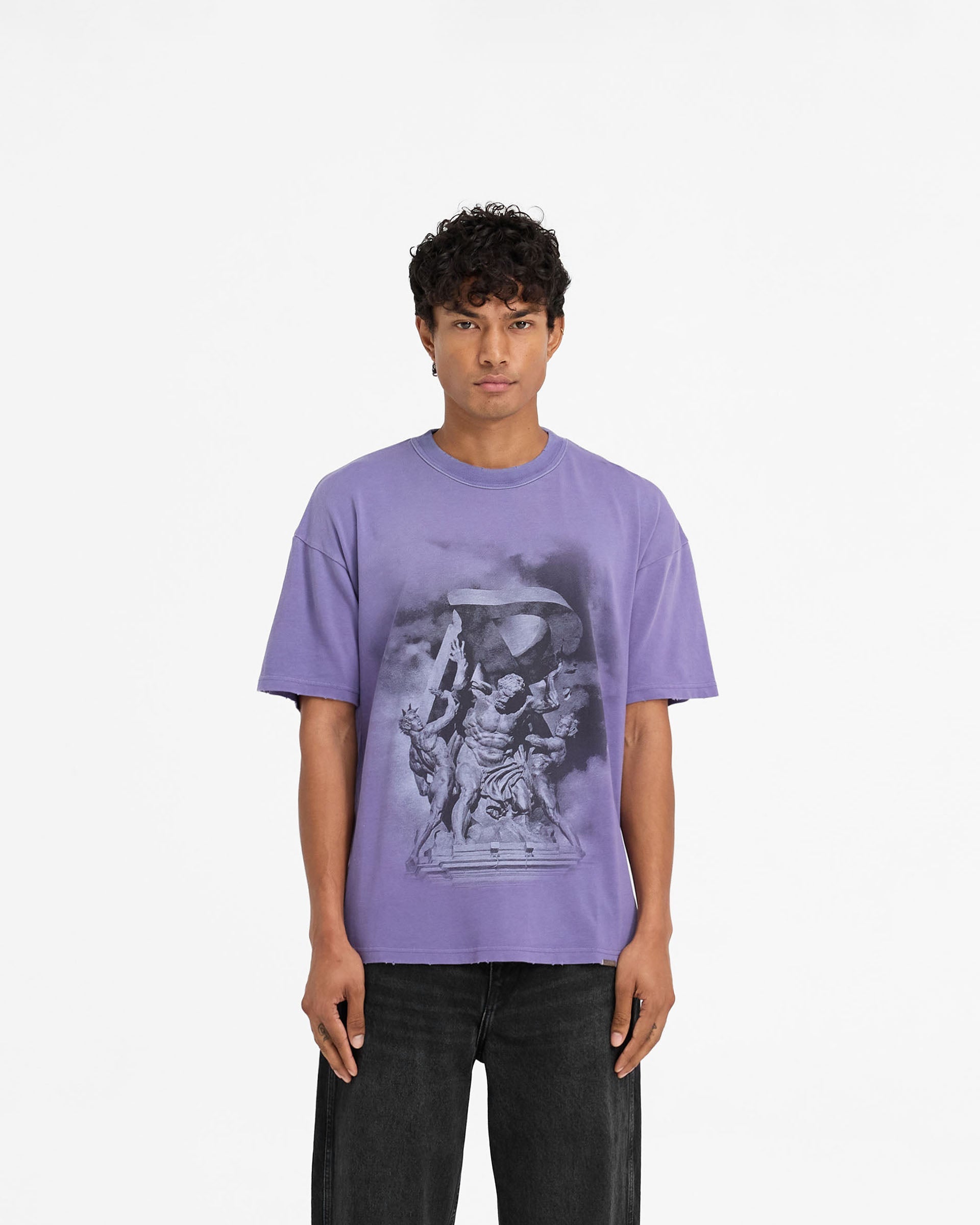Man wearing a purple t-shirt on a plain white background | Atlas T-Shirt in Purple | Slightly oversized t-shirt with unique puff print graphics | FW24 T-Shirts | Represent Clo