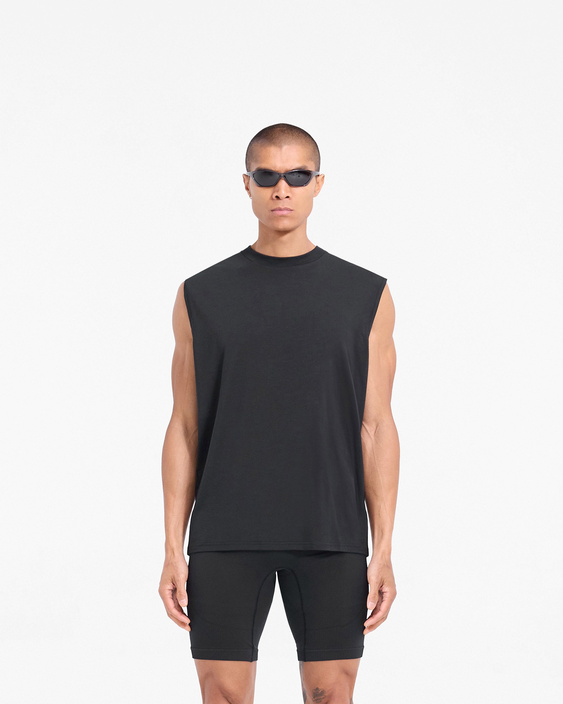 Man wearing a black tank top on a plain white background | 247 DNA Oversized Tank in Black | Lightweight gym tank with oversized fit | 247 T-Shirts | Represent Clo